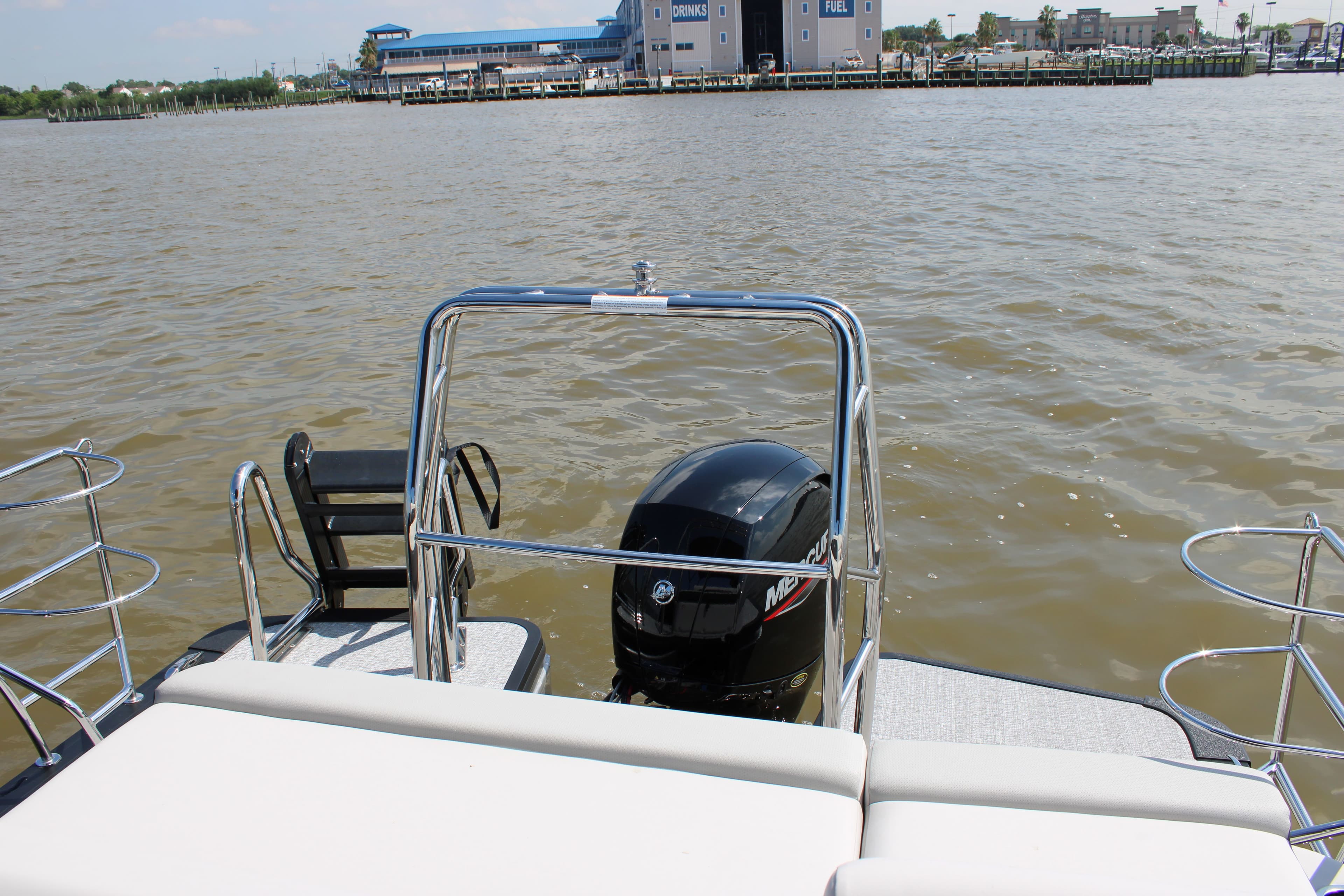 Harris Cruiser 230 boat 2026 with outboard motor on calm water.
