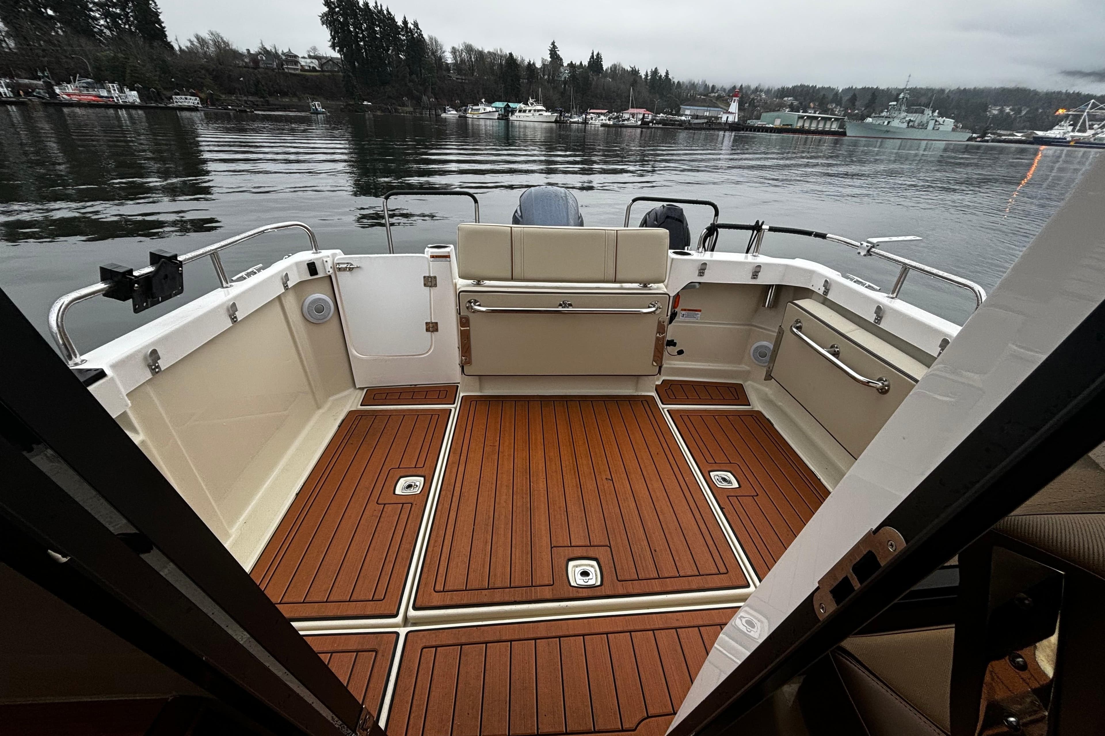 2022 Ranger Tugs R-23 boat deck with wood finish, overlooking calm waters.