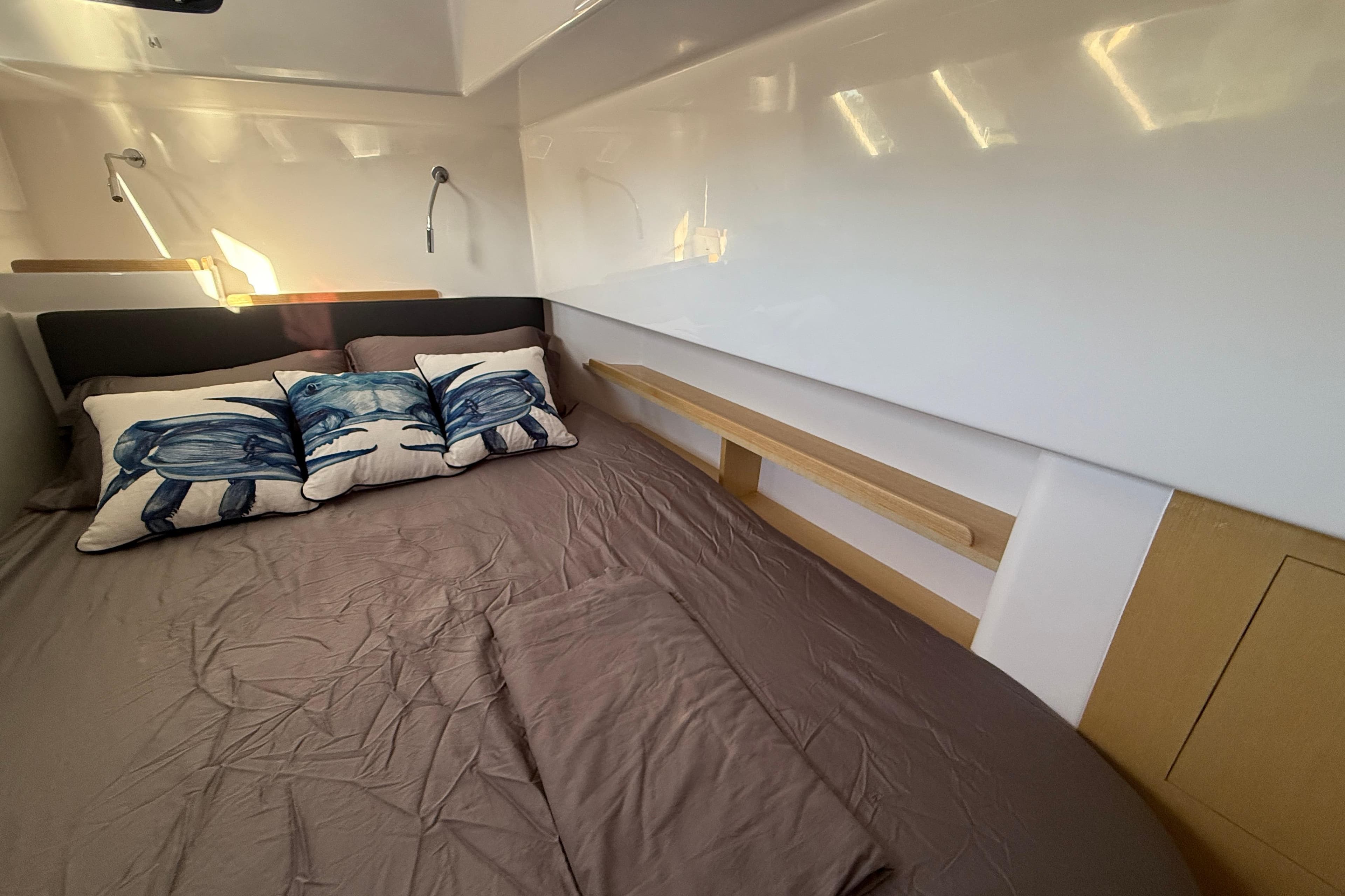 2024 Seawind 1370 cabin interior with cozy bed and decorative pillows.