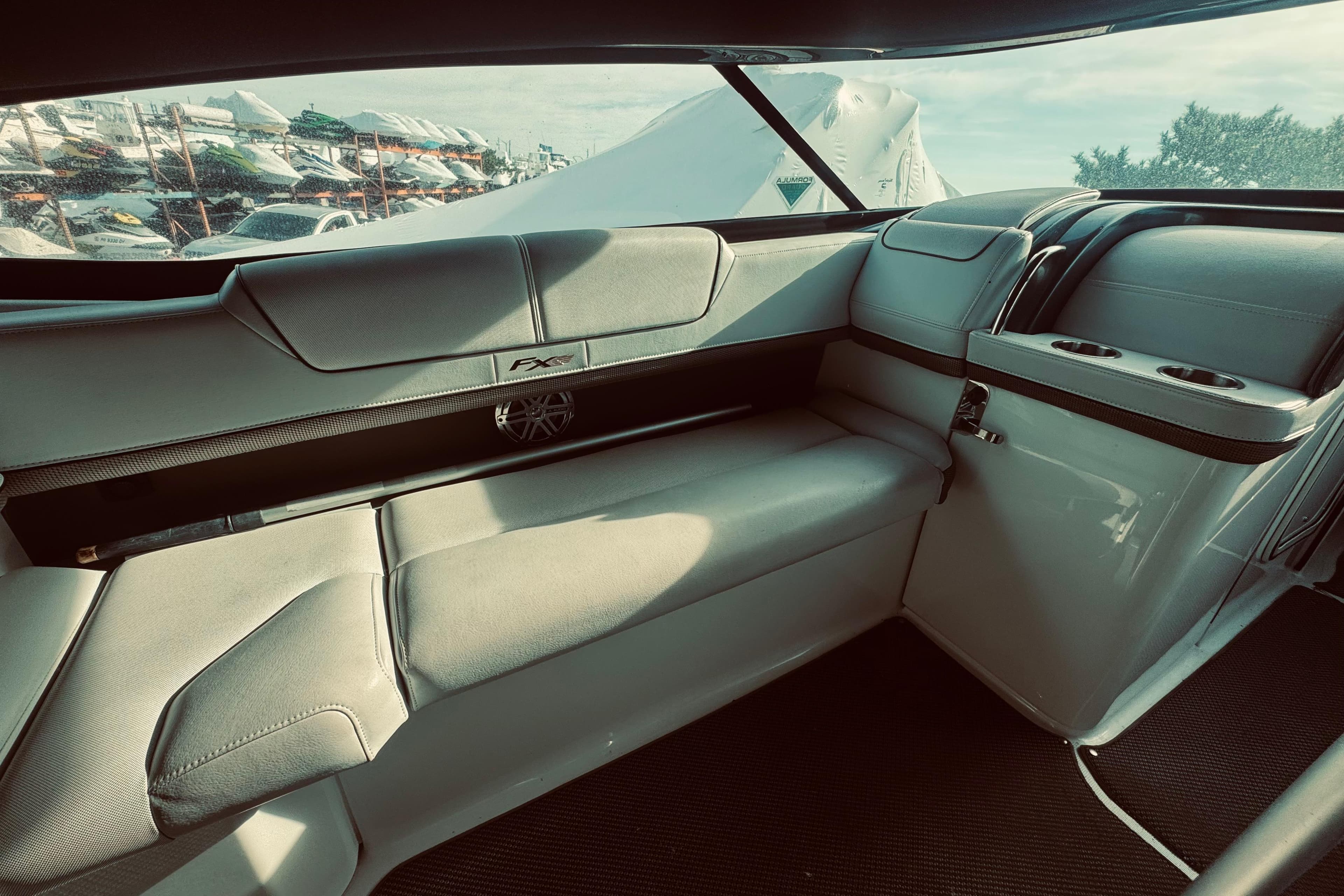 Luxurious interior of 2019 Formula 310 FX Bowrider with plush seating and cup holders.