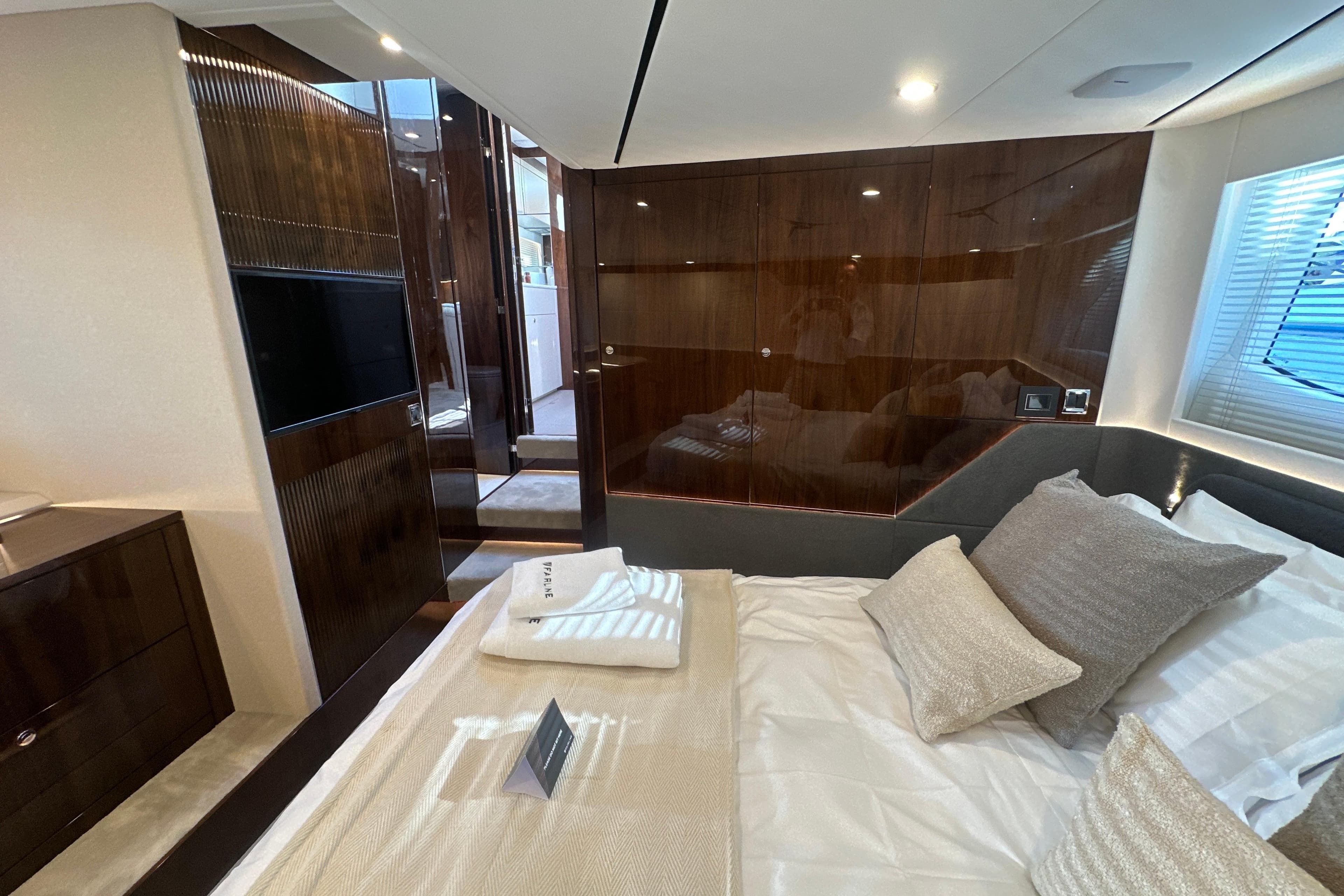 Luxurious interior of 2026 Fairline Targa 47 GT yacht bedroom with elegant wood finishes.