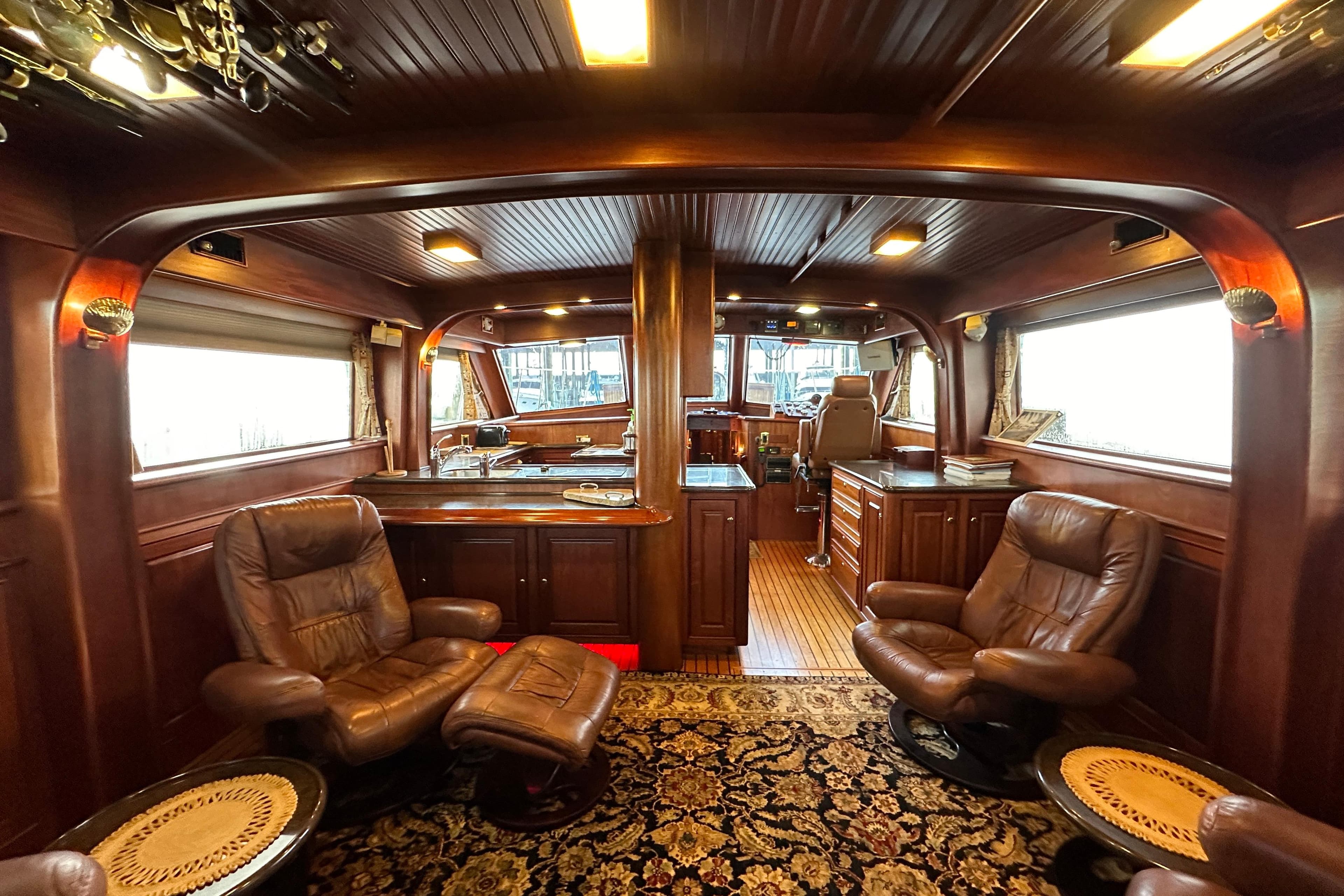Luxurious interior of a 1980 Bertram 58 Convertible yacht with leather seating and wood paneling.