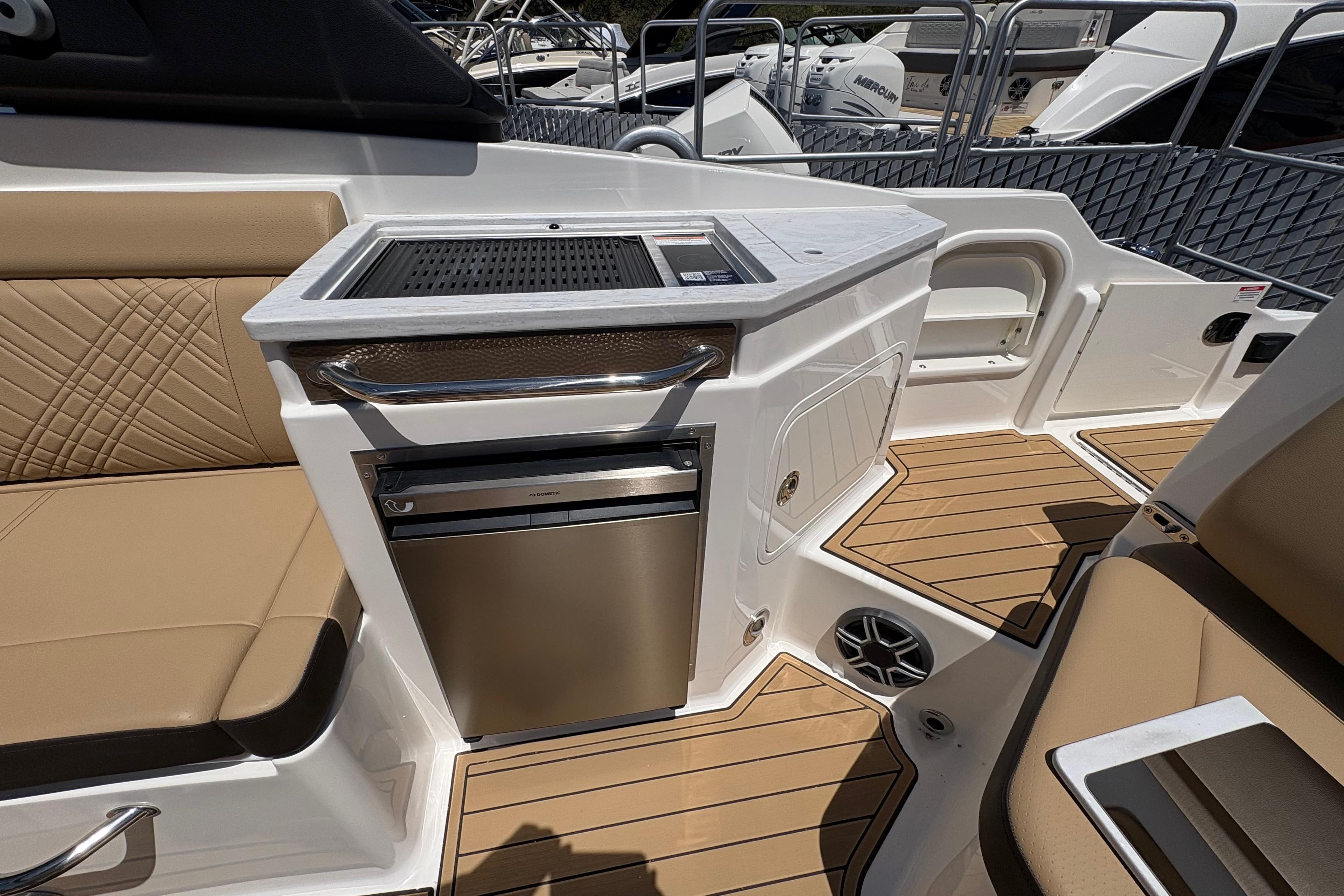 2026 Sea Ray SDX 290 Outboard boat interior with kitchenette and seating area.