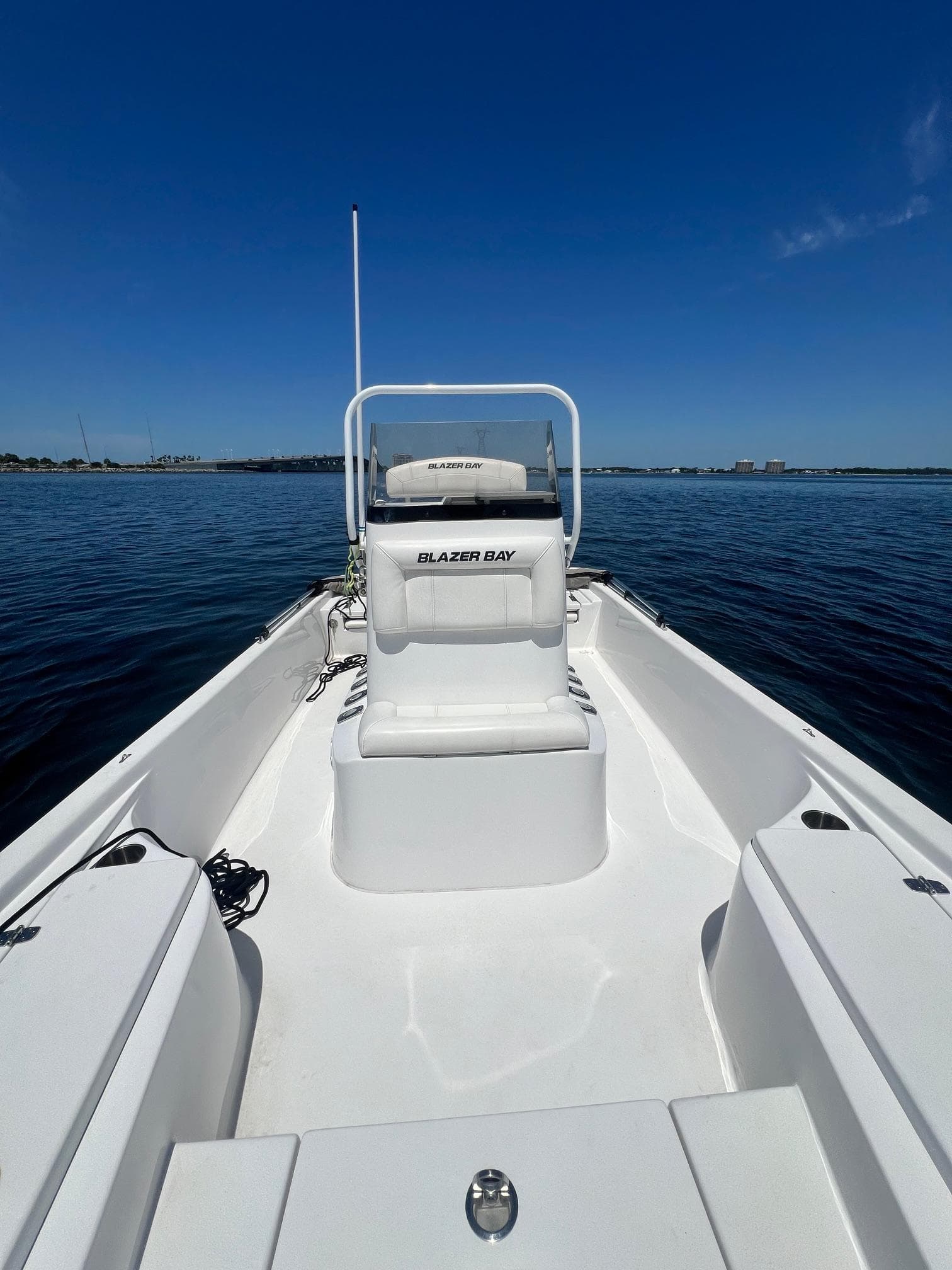 2021 Blazer Bay 2200 boat on calm water under clear blue sky.