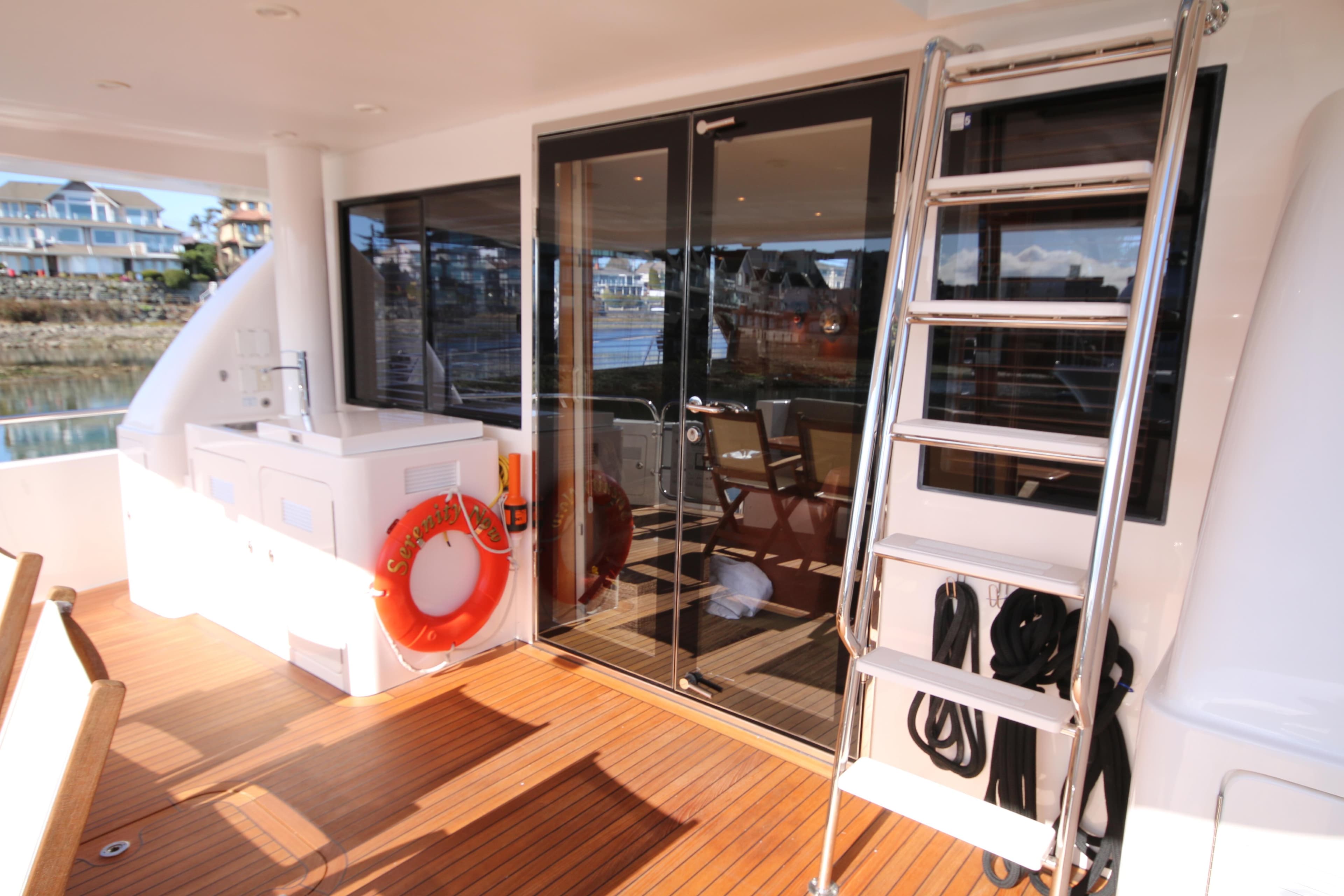 2004 West Bay 68 Sonship Pilothouse yacht deck with ladder and life preserver.