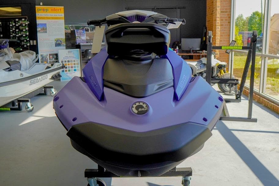 2026 Sea-Doo Spark for 3 jet ski displayed in showroom, featuring sleek design and vibrant color.