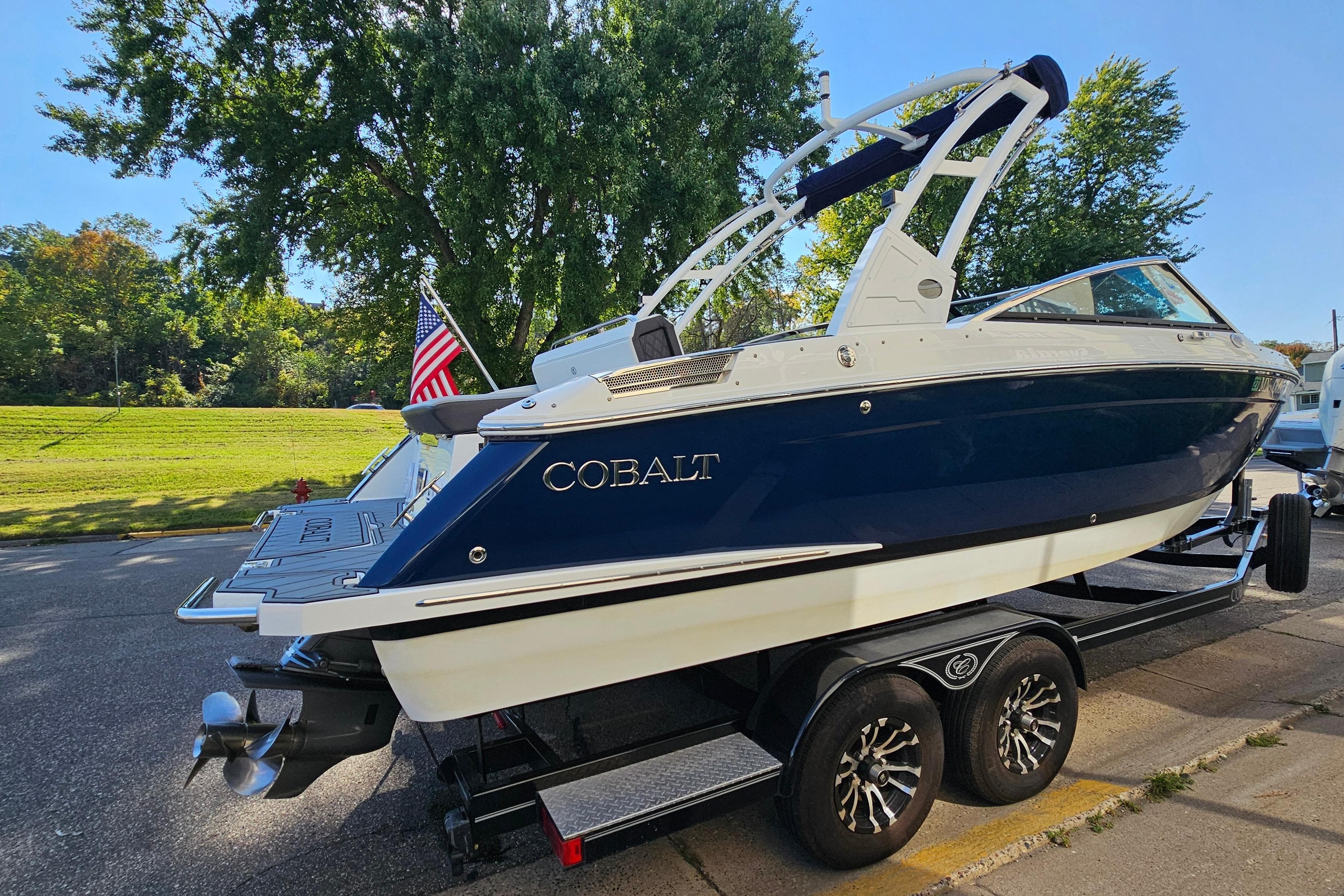 2022 Cobalt R4 boat on trailer, parked outdoors with trees in background.