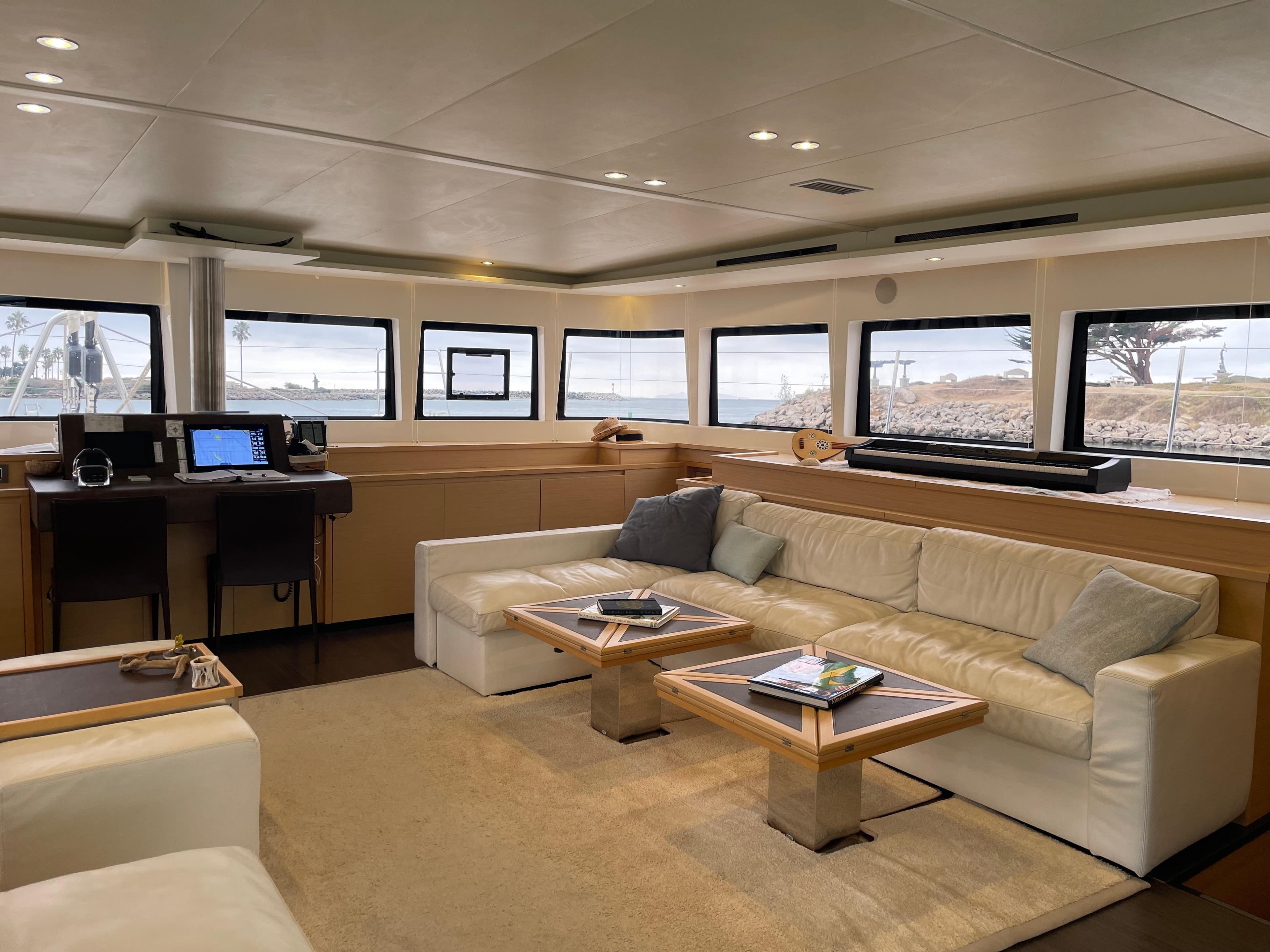 Luxurious interior of 2019 Lagoon 620 yacht with plush seating and panoramic windows.