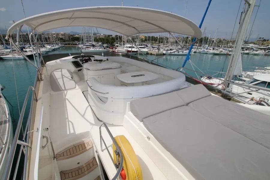 Luxurious 2001 Princess 61 yacht with spacious deck and canopy in marina.