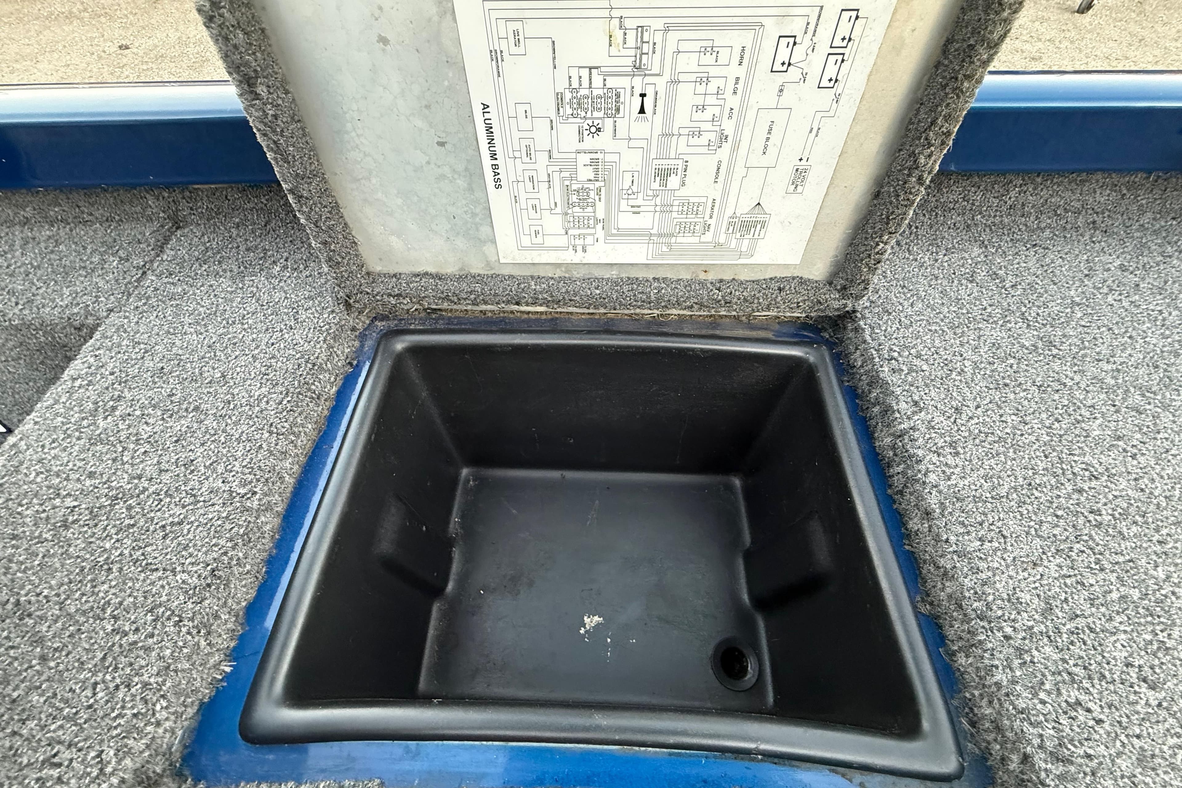 Open storage compartment in 2020 Triton 17 TX boat with wiring diagram.
