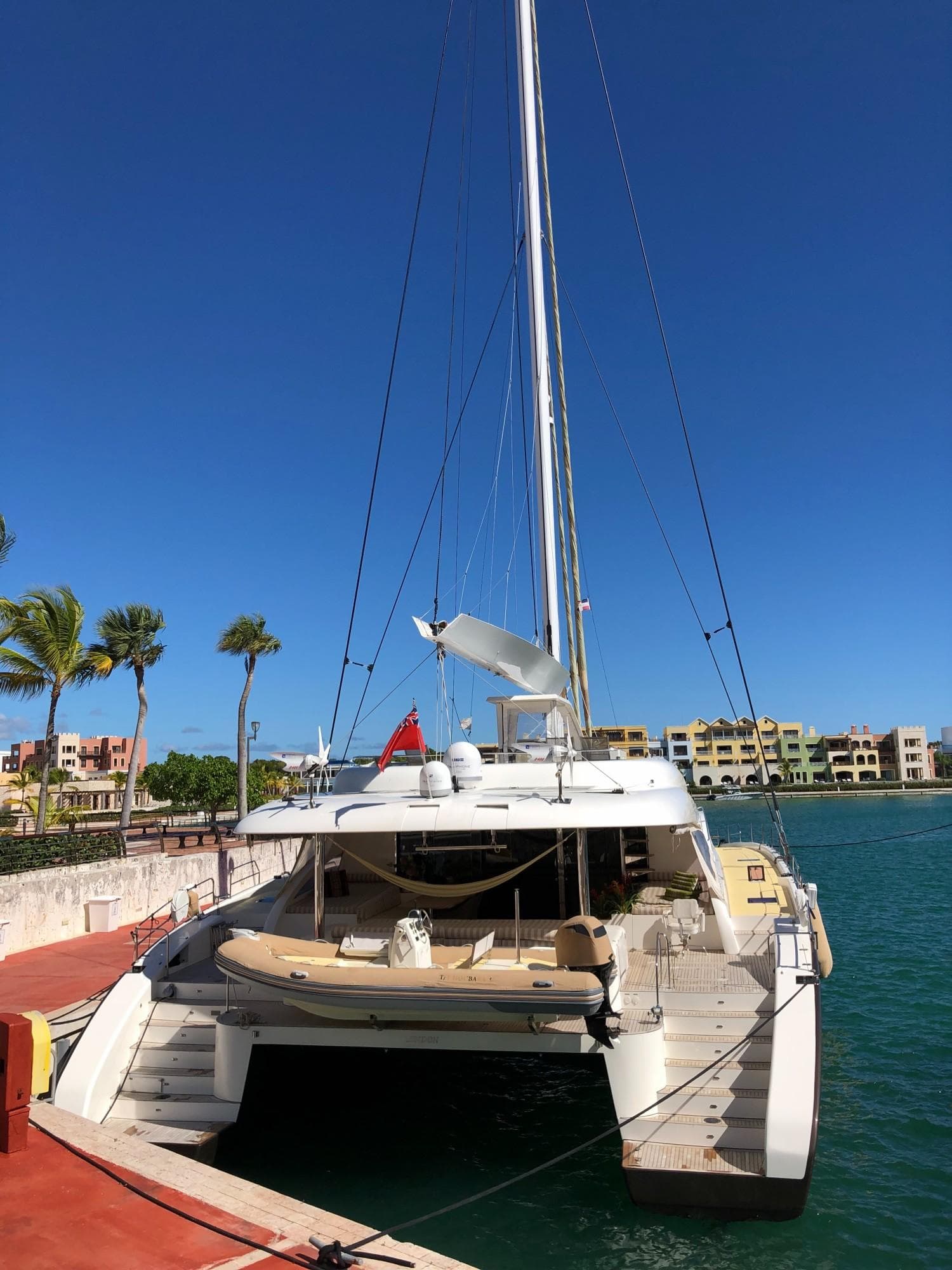 Luxury Sunreef 82 DD catamaran docked, 2012 model, clear blue sky, waterfront view.
