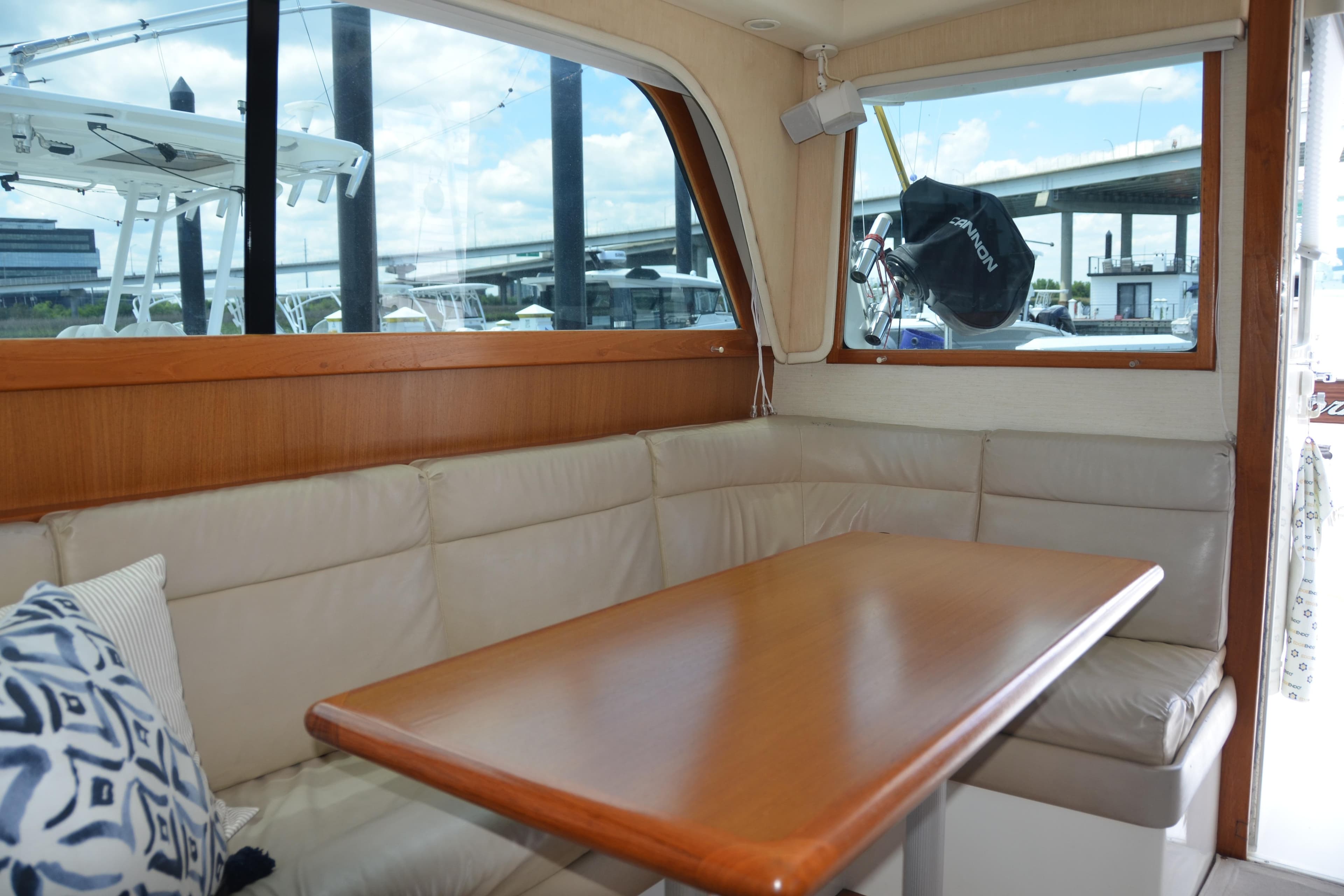 Interior of 2001 Cabo 35 Flybridge with cushioned seating and wooden table.