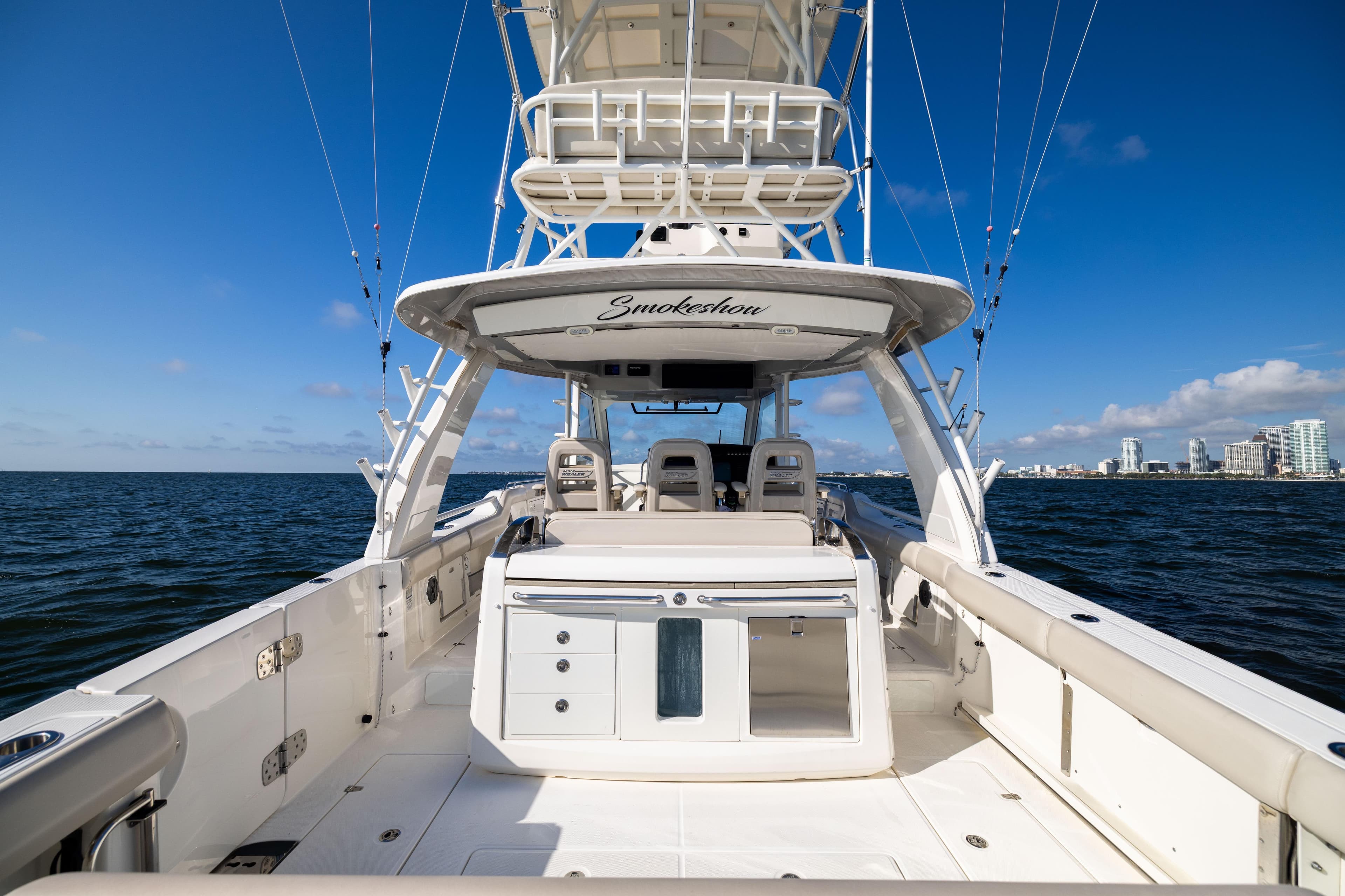 2021 Boston Whaler 420 Outrage boat on open water with city skyline in background.