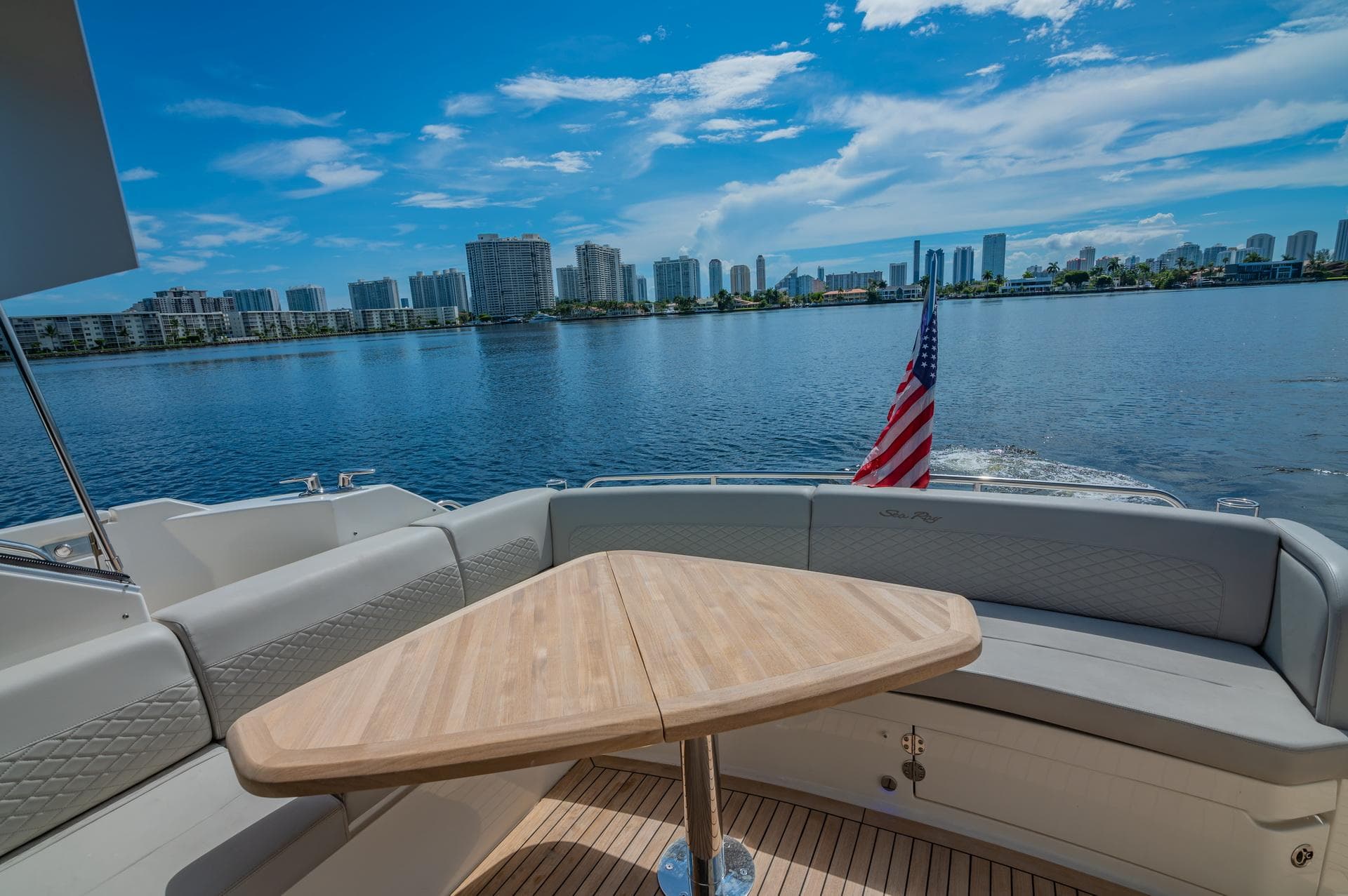 2018 Sea Ray L590 yacht with a scenic waterfront view and American flag.