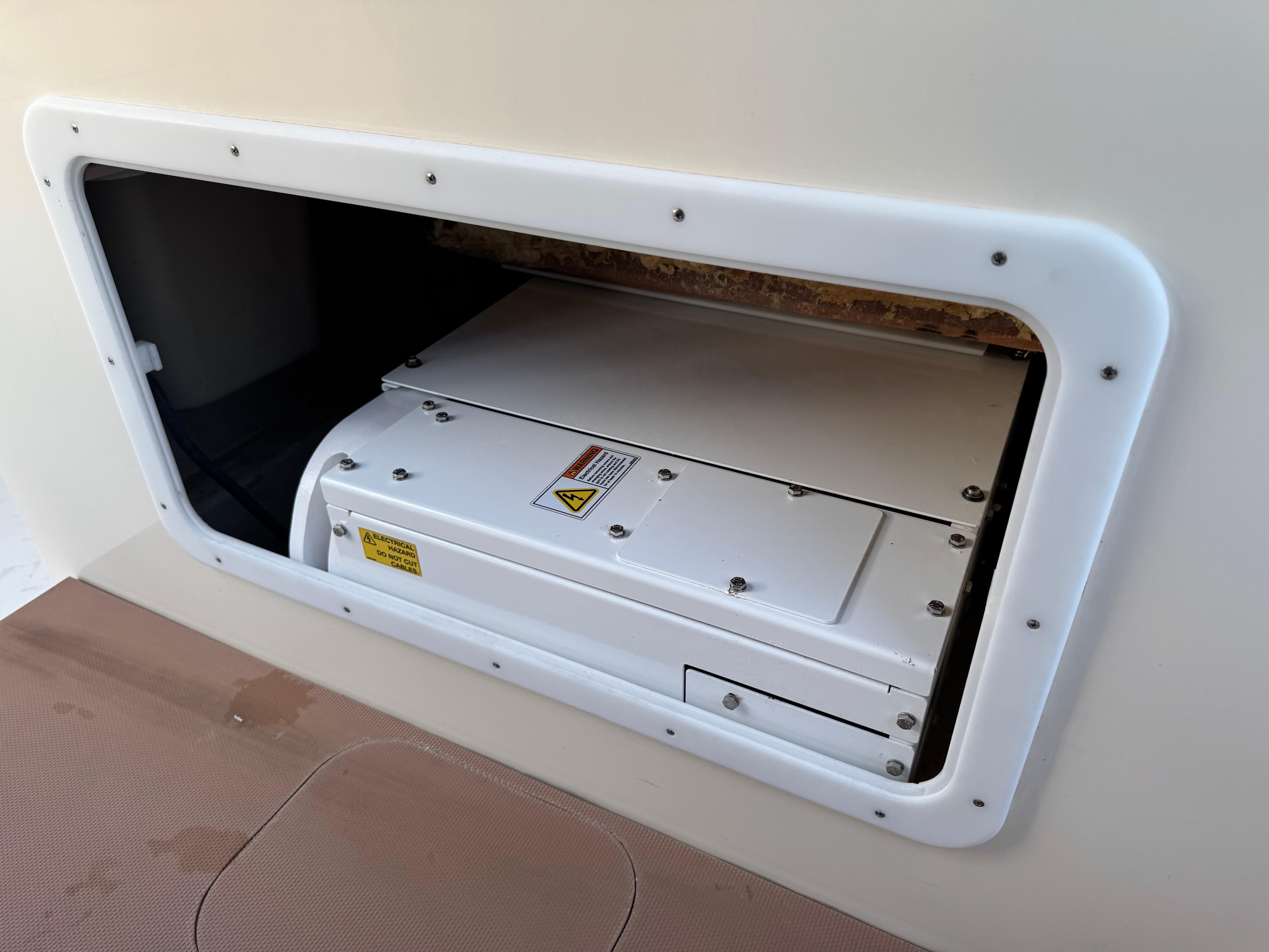 Storage compartment on a 2021 Scout 330 LXF boat, featuring a secured white panel.