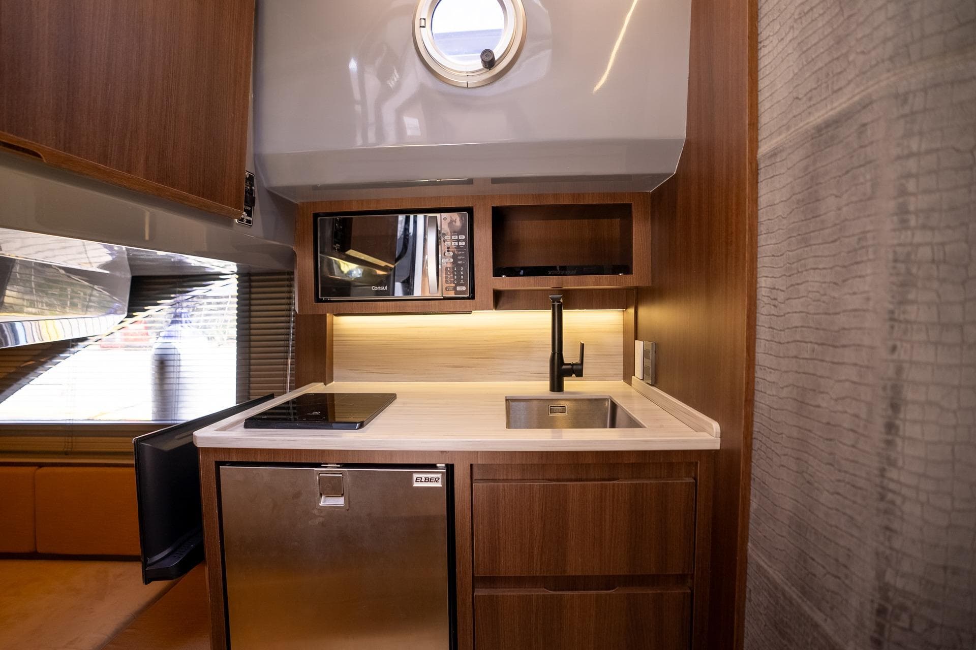 Modern kitchen in 2026 Hanover 447 yacht with wood cabinetry and stainless steel appliances.