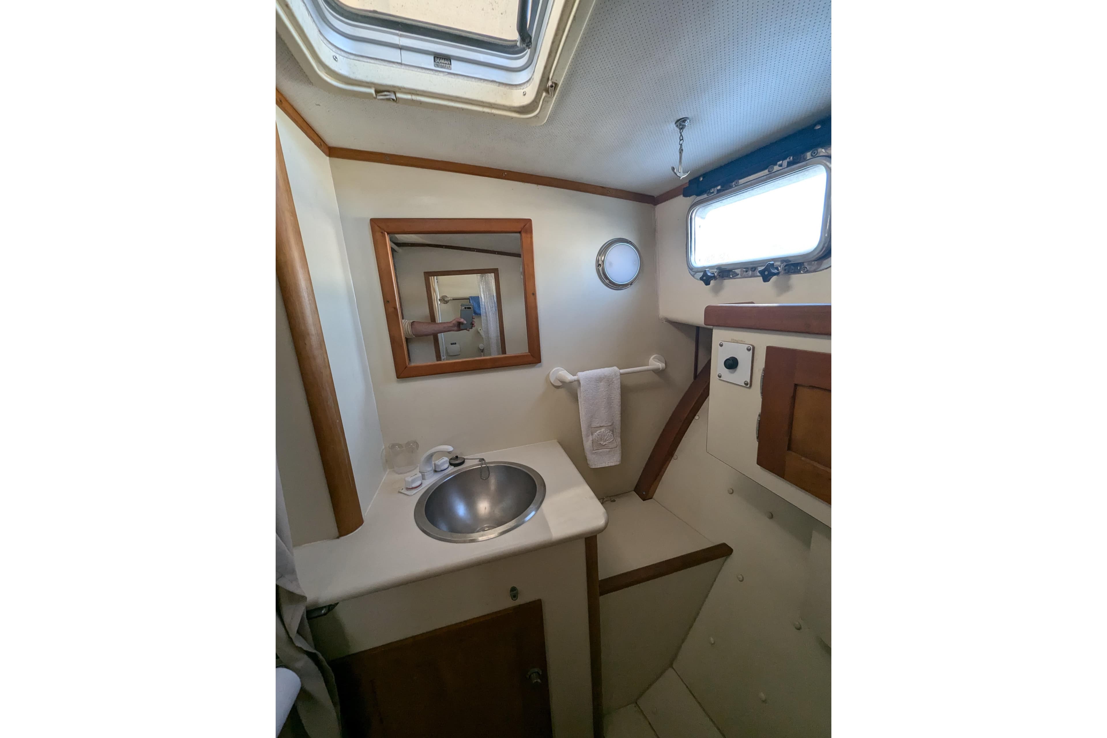 Bathroom interior of 2000 Duffy Flybridge 37 boat with sink and porthole window.