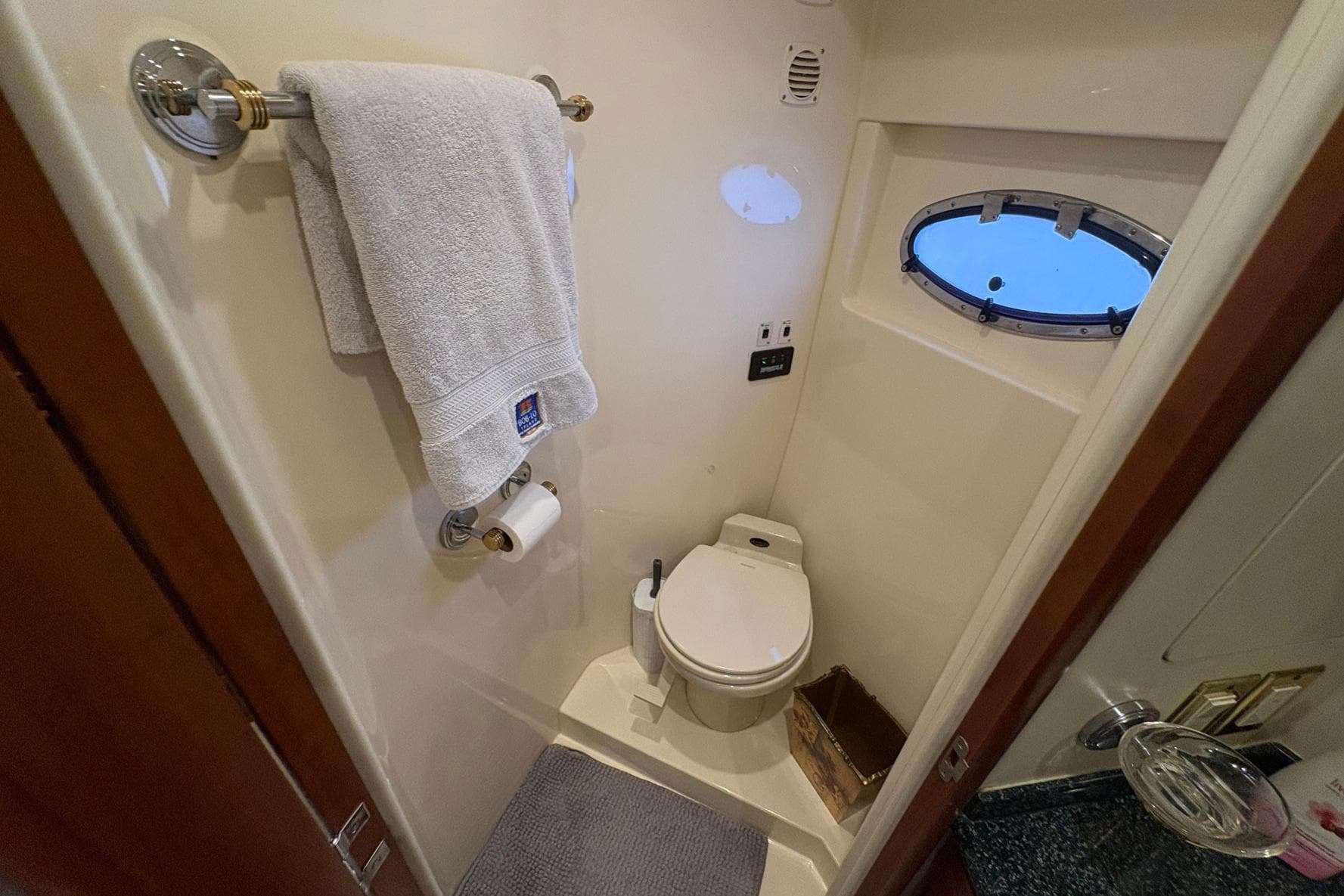 Bathroom interior of 1999 Carver 530 Voyager Pilothouse yacht with towel and porthole window.
