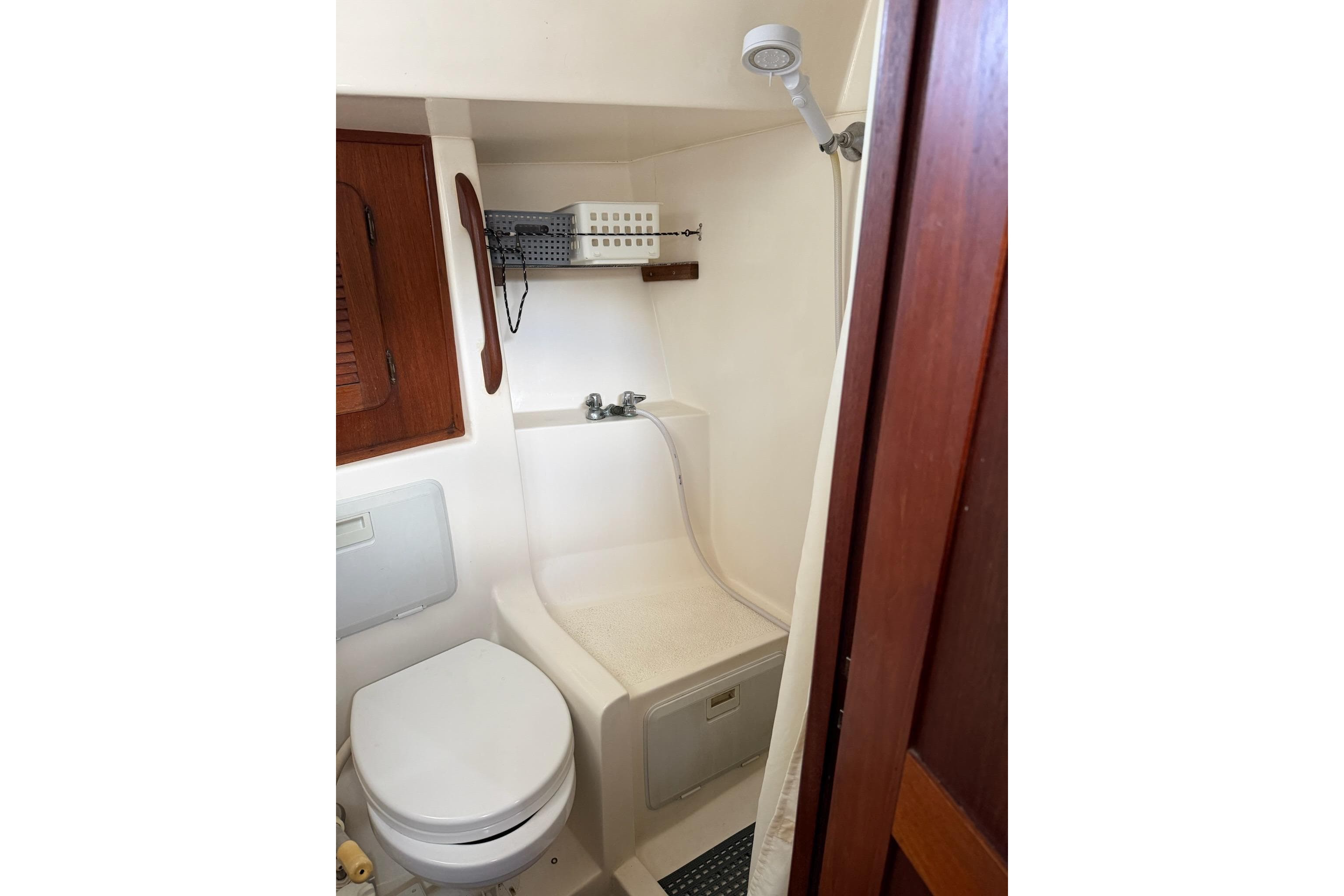 Compact bathroom in 1984 Morgan 384 yacht with shower and toilet.