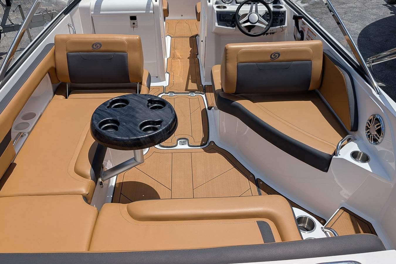2023 Hurricane SunDeck 235 OB boat interior with tan seating and black table.
