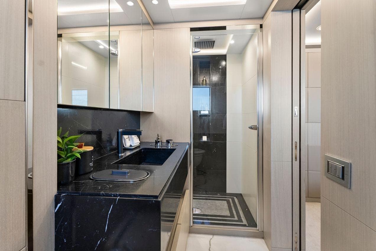 Luxurious bathroom on a 2016 Benetti 116 yacht with sleek black marble and modern fixtures.