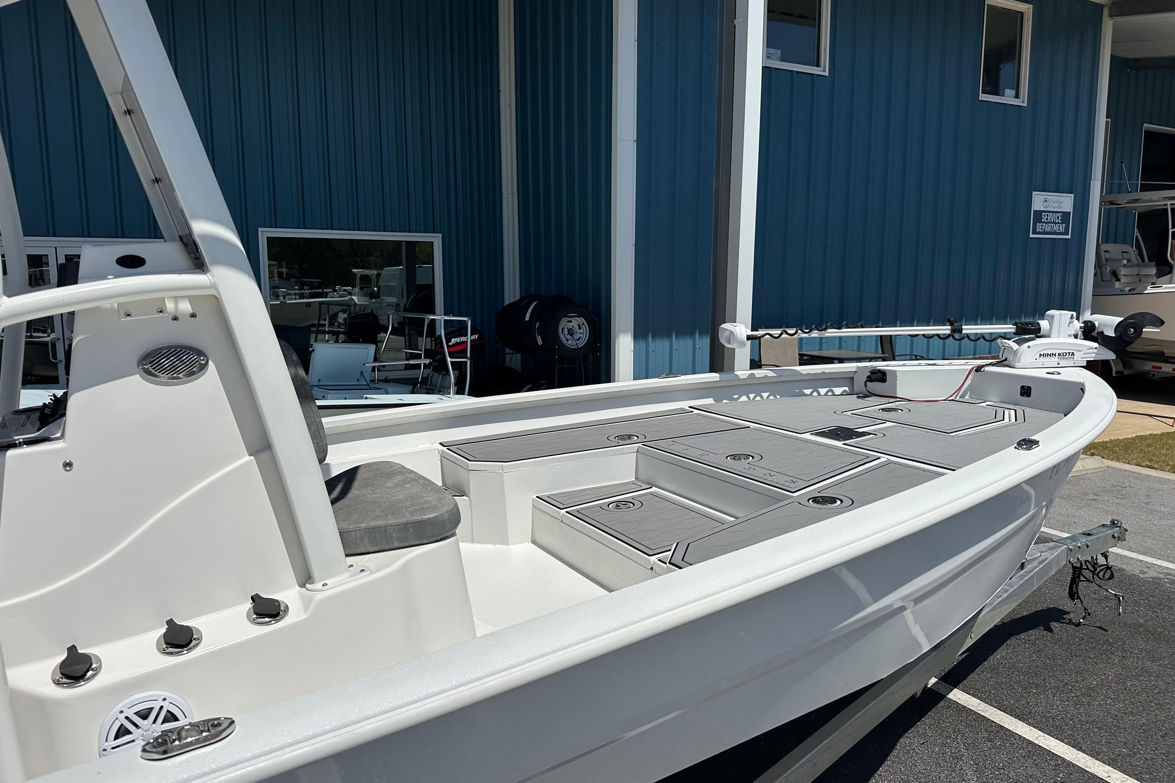 2024 Avid 23 Mag boat with sleek design, docked near blue building.
