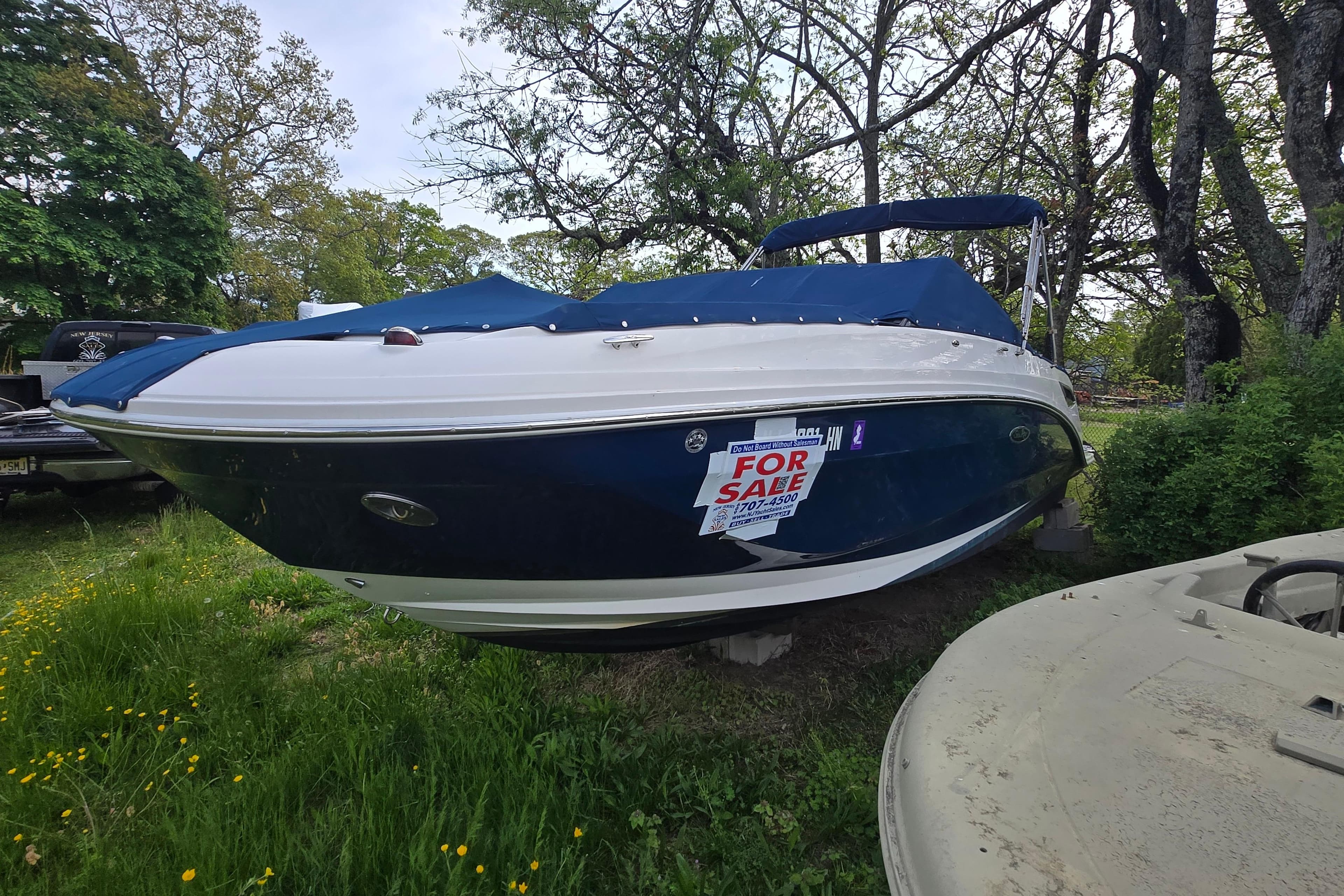 2018 Sea Ray SDX 250 boat with blue cover, for sale sign displayed.