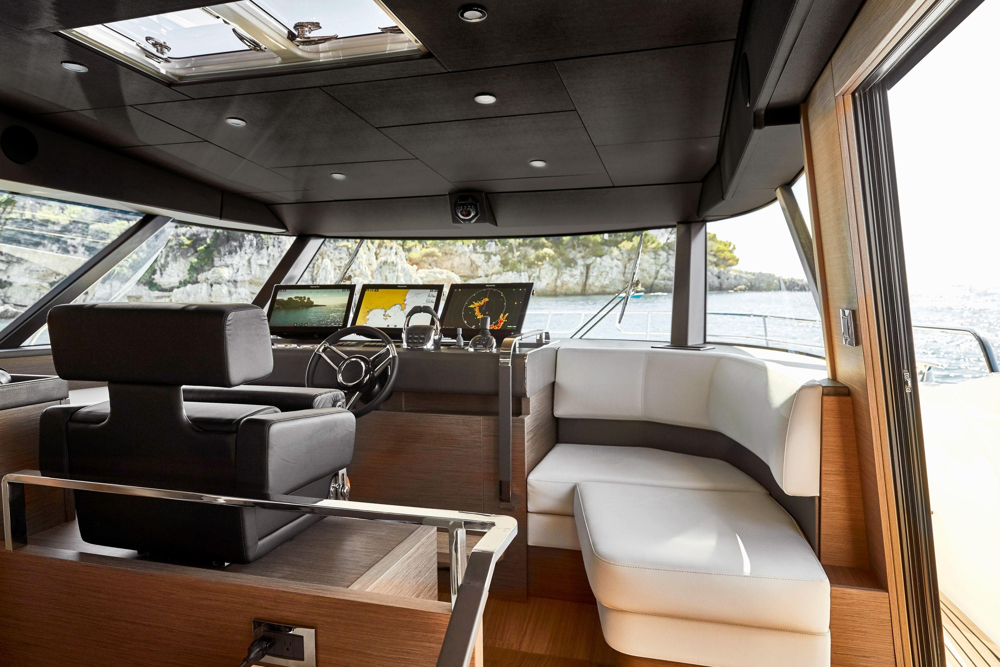 Luxurious interior of 2026 Prestige X70 yacht with modern helm and seating area.