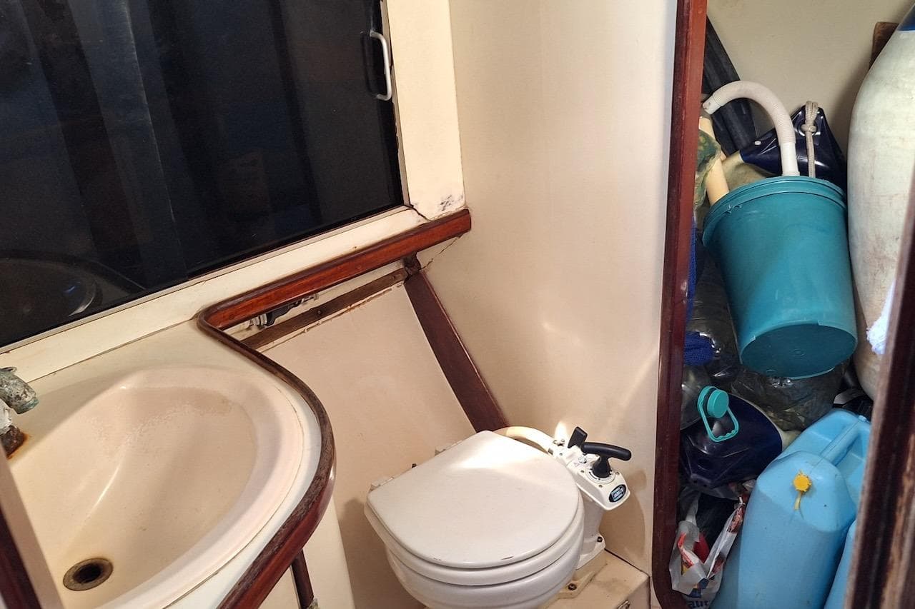 Compact bathroom on 1985 Gulfstar Hirsch 45 CC sailboat with sink and toilet.