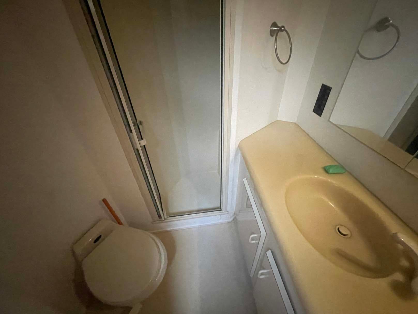 Bathroom interior of 1998 Viking 50 Convertible yacht with shower, sink, and toilet.