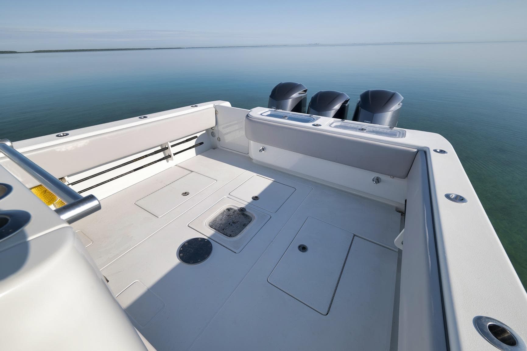 2021 Contender 39 ST boat deck with triple outboard motors on calm water.
