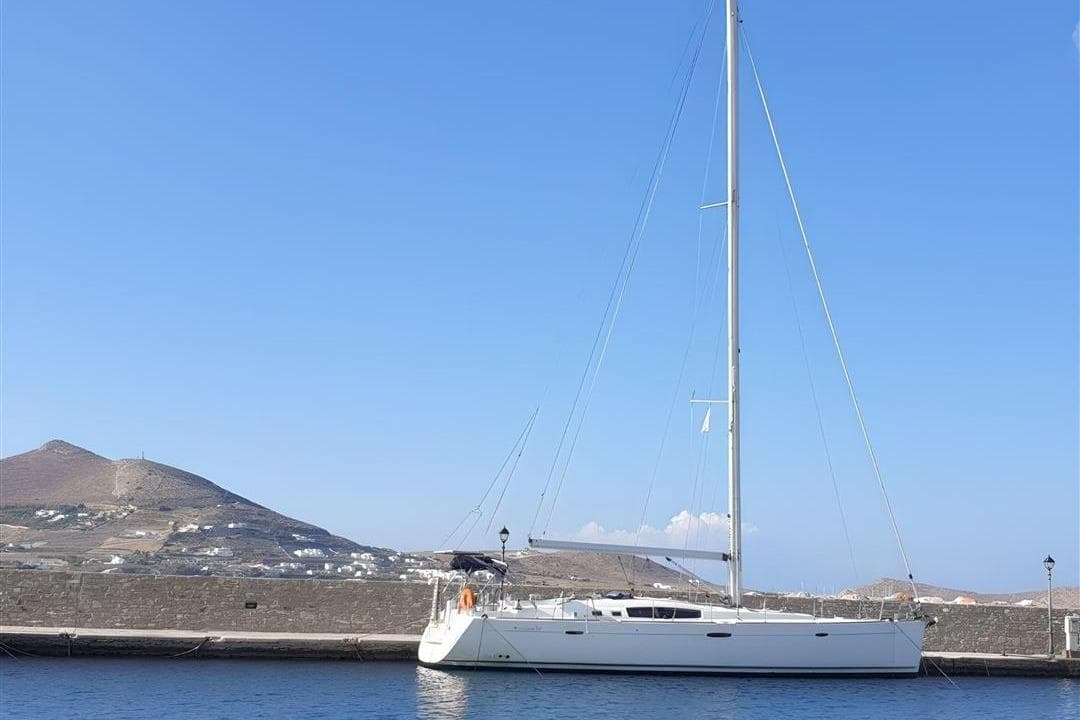 2009 Beneteau Oceanis 54 yacht docked by a scenic coastal landscape.