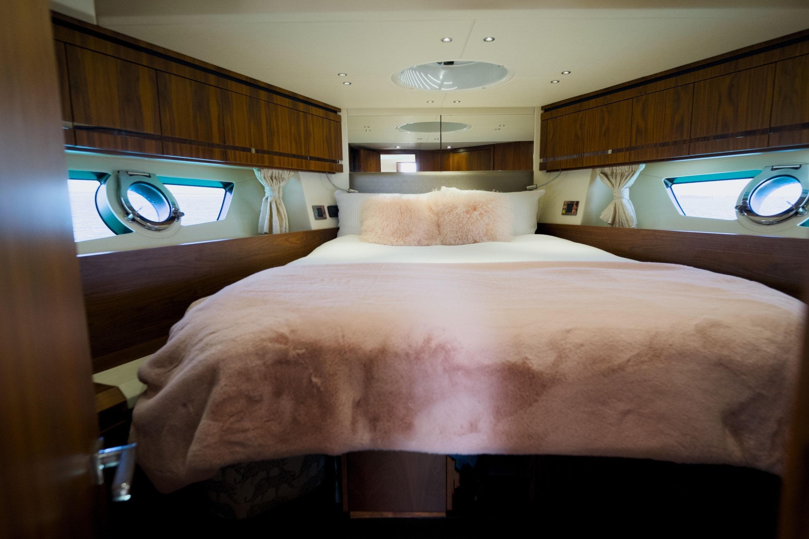 Luxurious bedroom interior of 2013 Sunseeker San Remo 485 yacht with plush bedding.