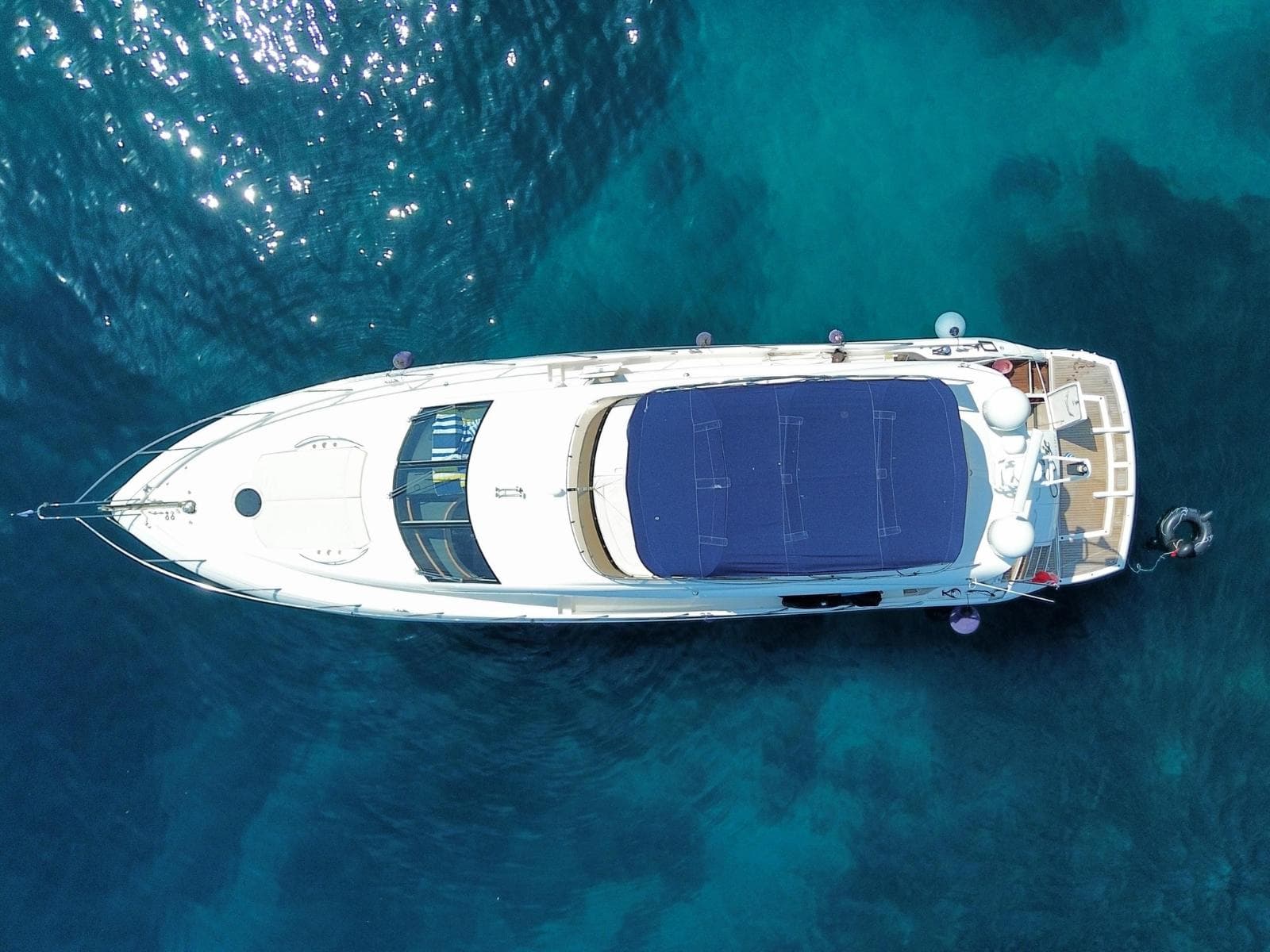 Aerial view of 2008 Sunseeker Manhattan 60 yacht on clear blue water.