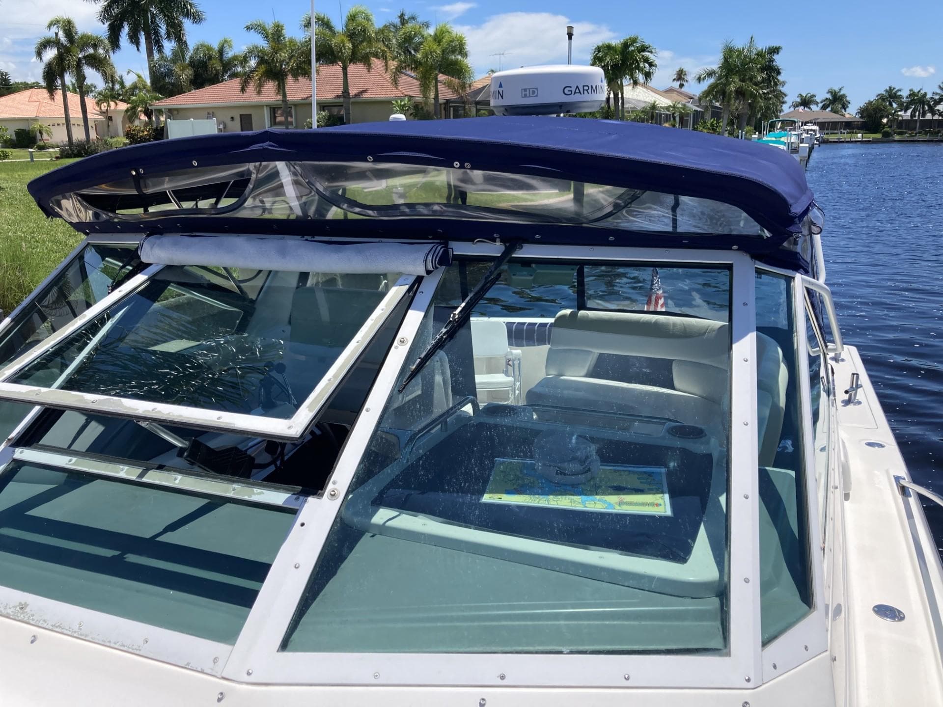 2000 Tiara Yachts 3100 Open boat with blue canopy on a sunny day by the water.
