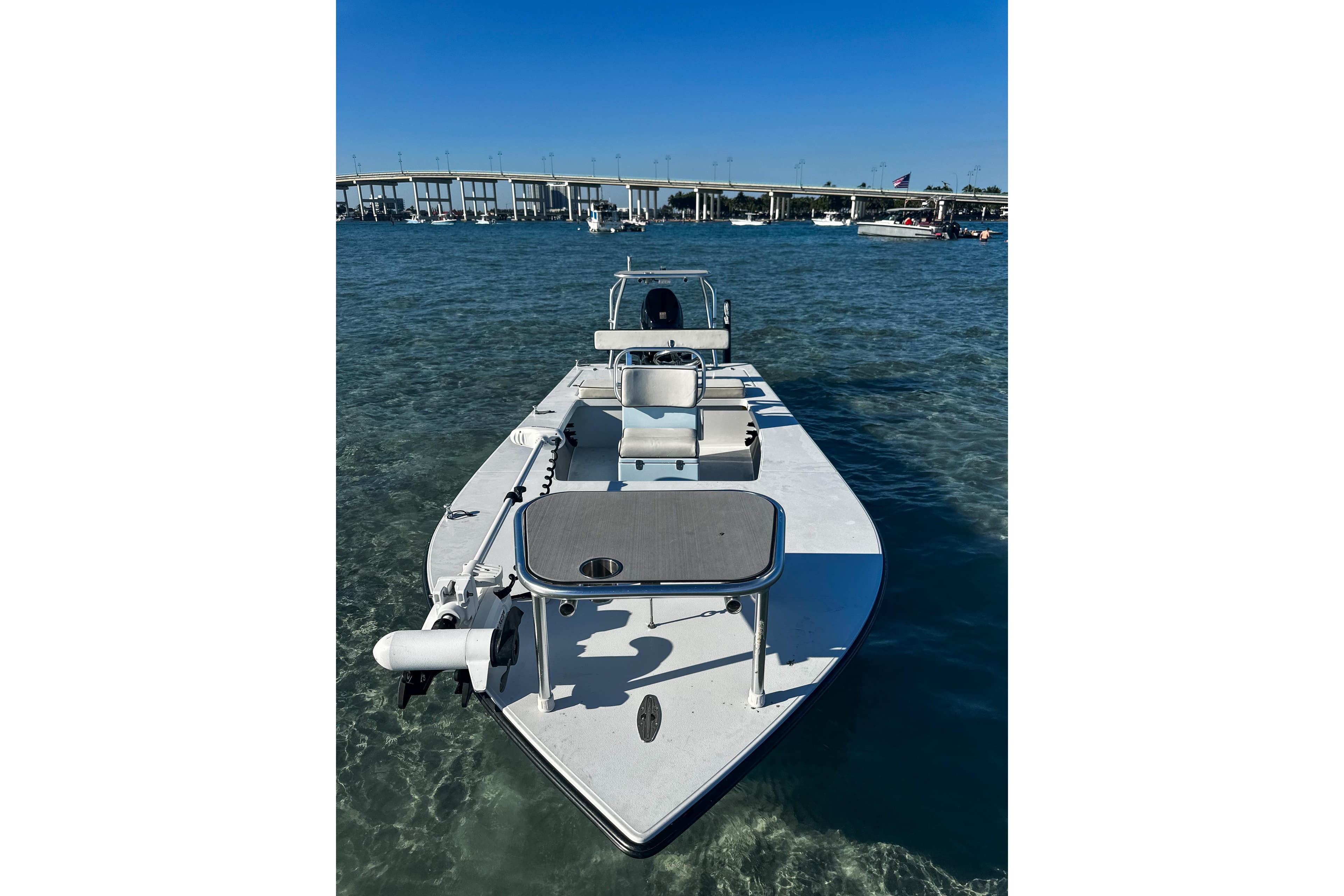 2020 East Cape Evo V boat on clear water near a bridge.