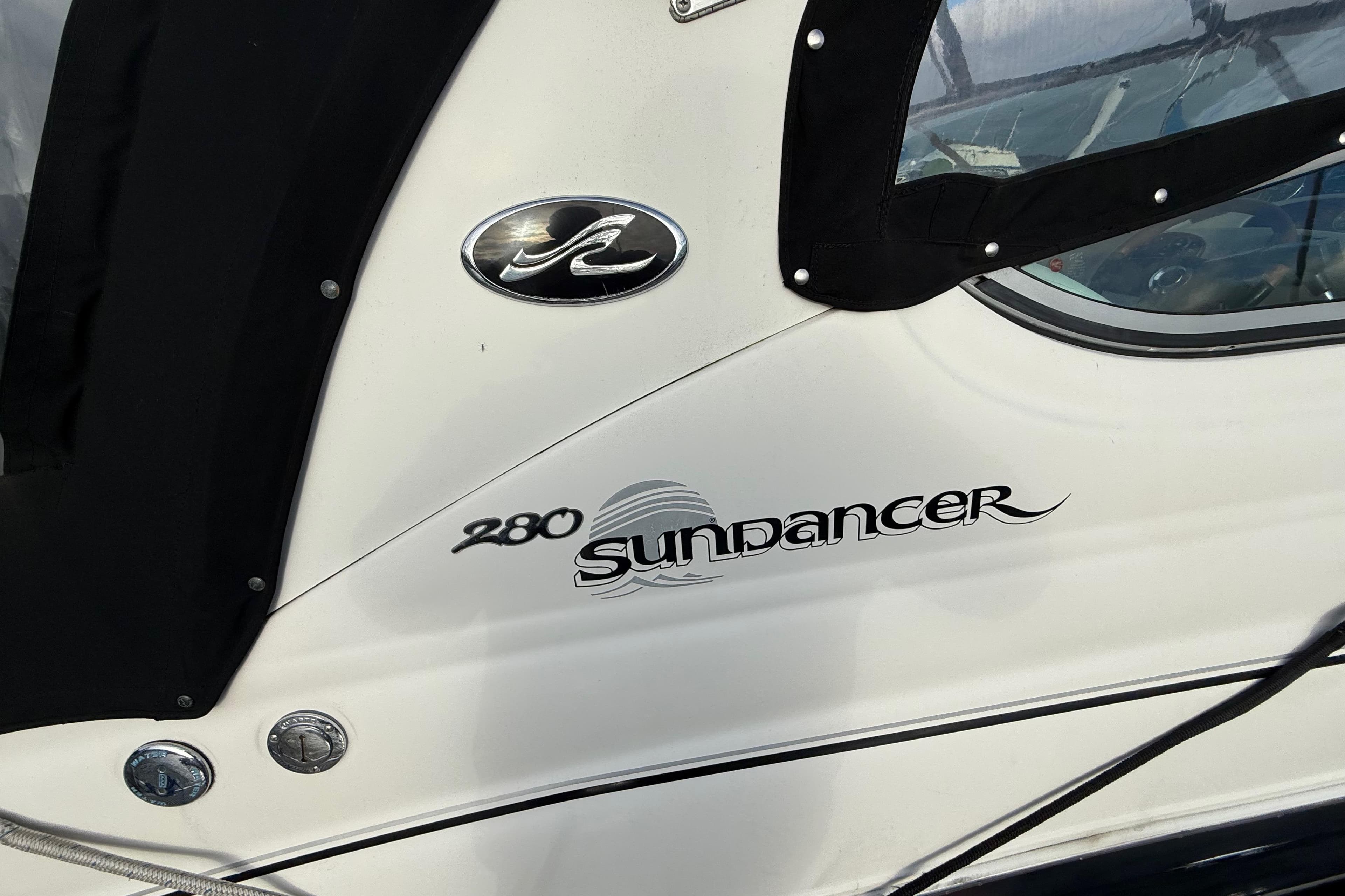 2007 Sea Ray 280 Cuddy Cabin boat with Sundancer logo and black canopy.