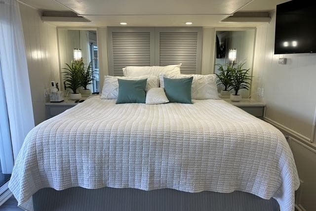 Luxurious bedroom in a 1999 Sumerset 18x82 houseboat with elegant decor and cozy bedding.