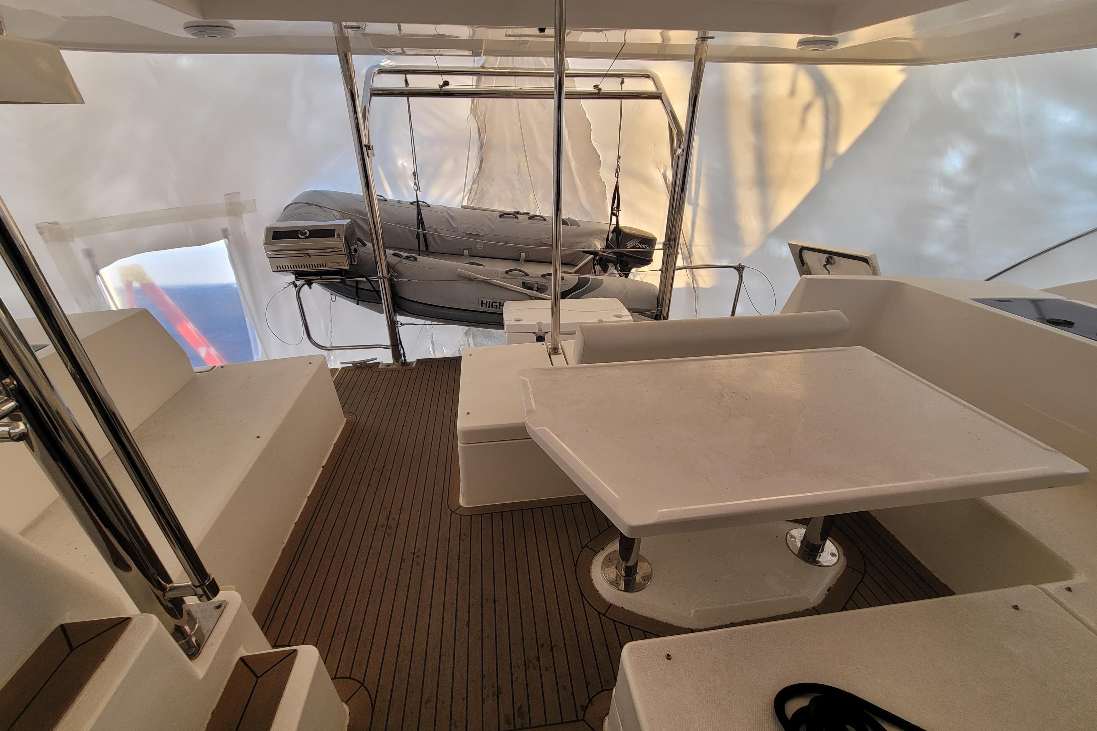 2018 Leopard 40 yacht interior with seating, table, and dinghy on deck.