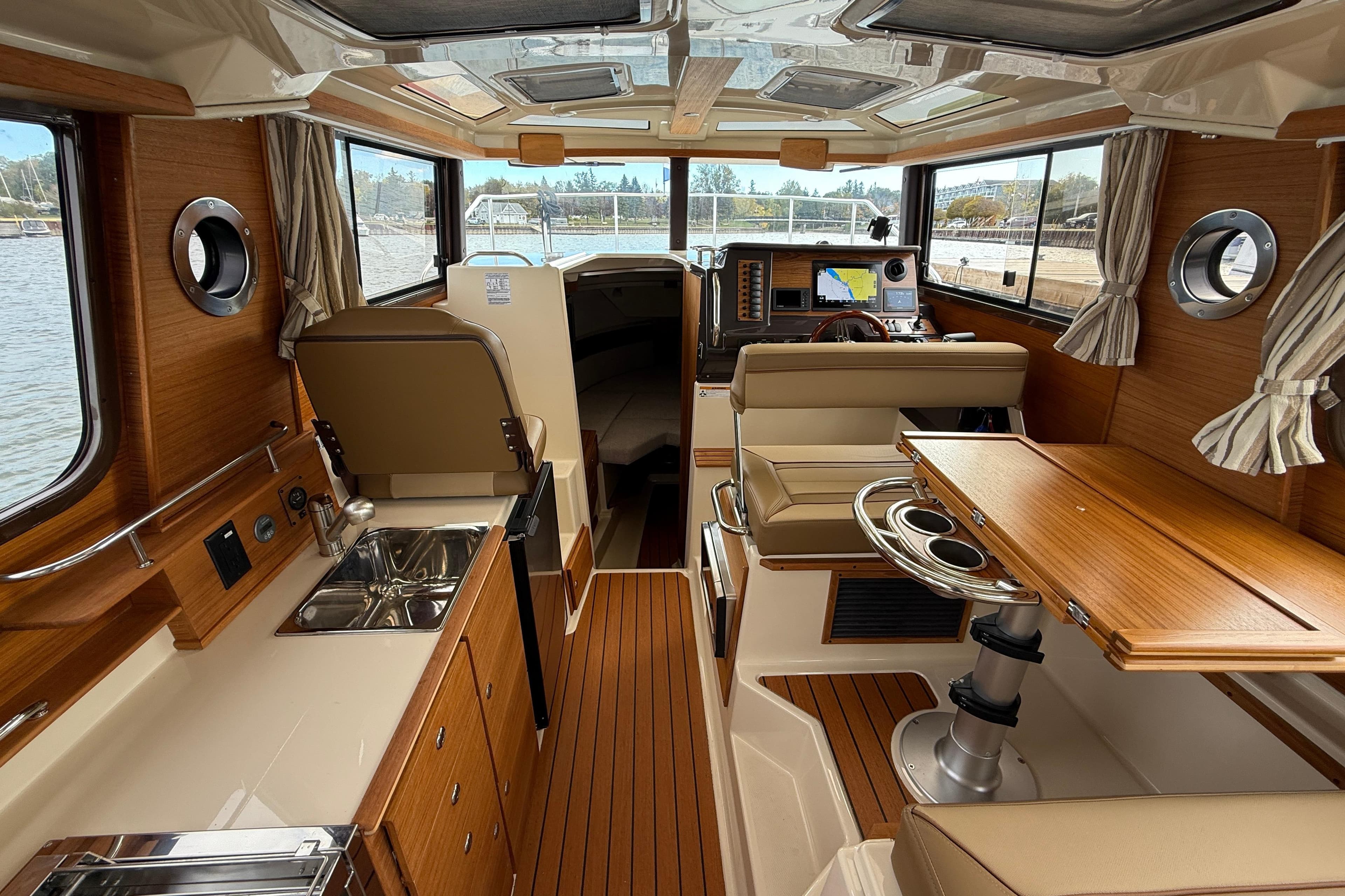 2025 Ranger Tugs R-27 interior with wood finish, kitchenette, and navigation area.