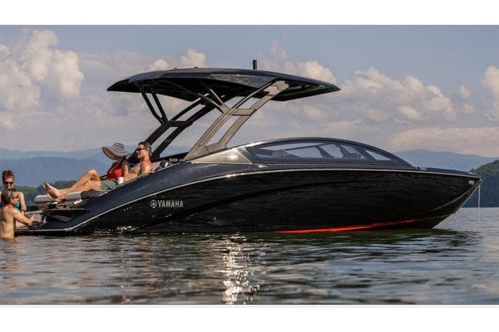 2025 Yamaha Boats 275 SD on calm water with passengers enjoying the sun.