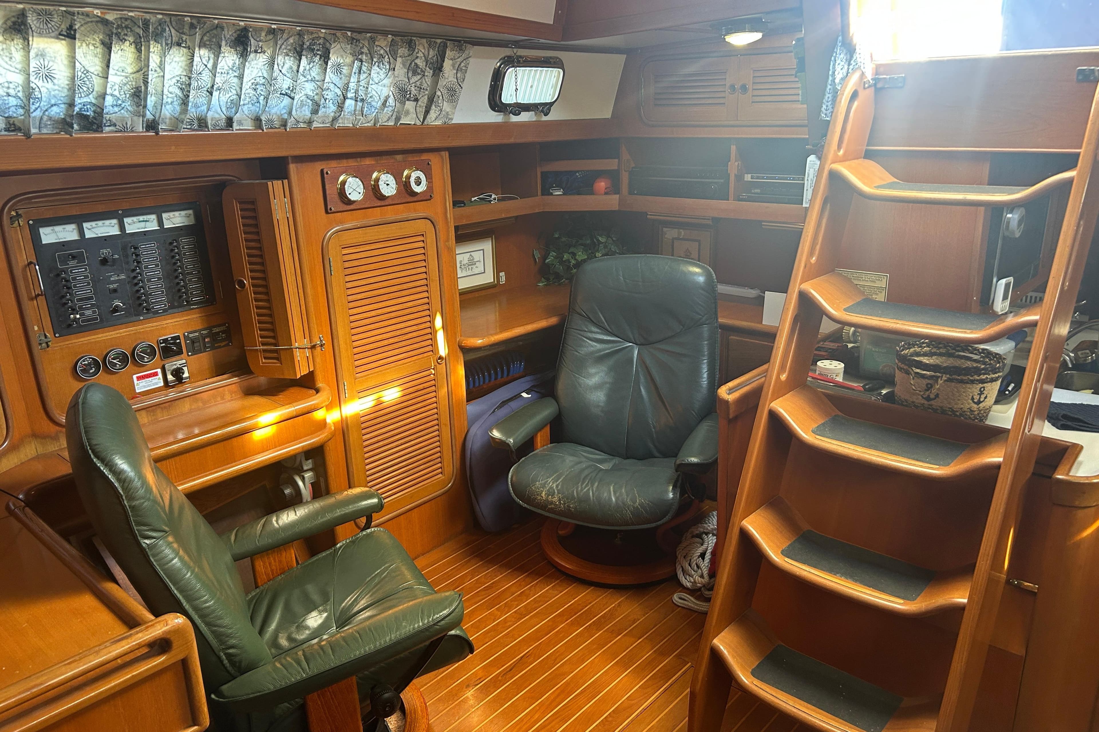 Interior of 1995 Tayana 48 yacht with wooden furnishings and leather chairs.