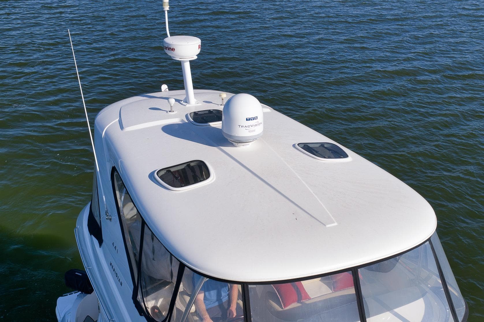 2012 Meridian 441 Sedan yacht on water, featuring sleek white design and advanced navigation equipment.