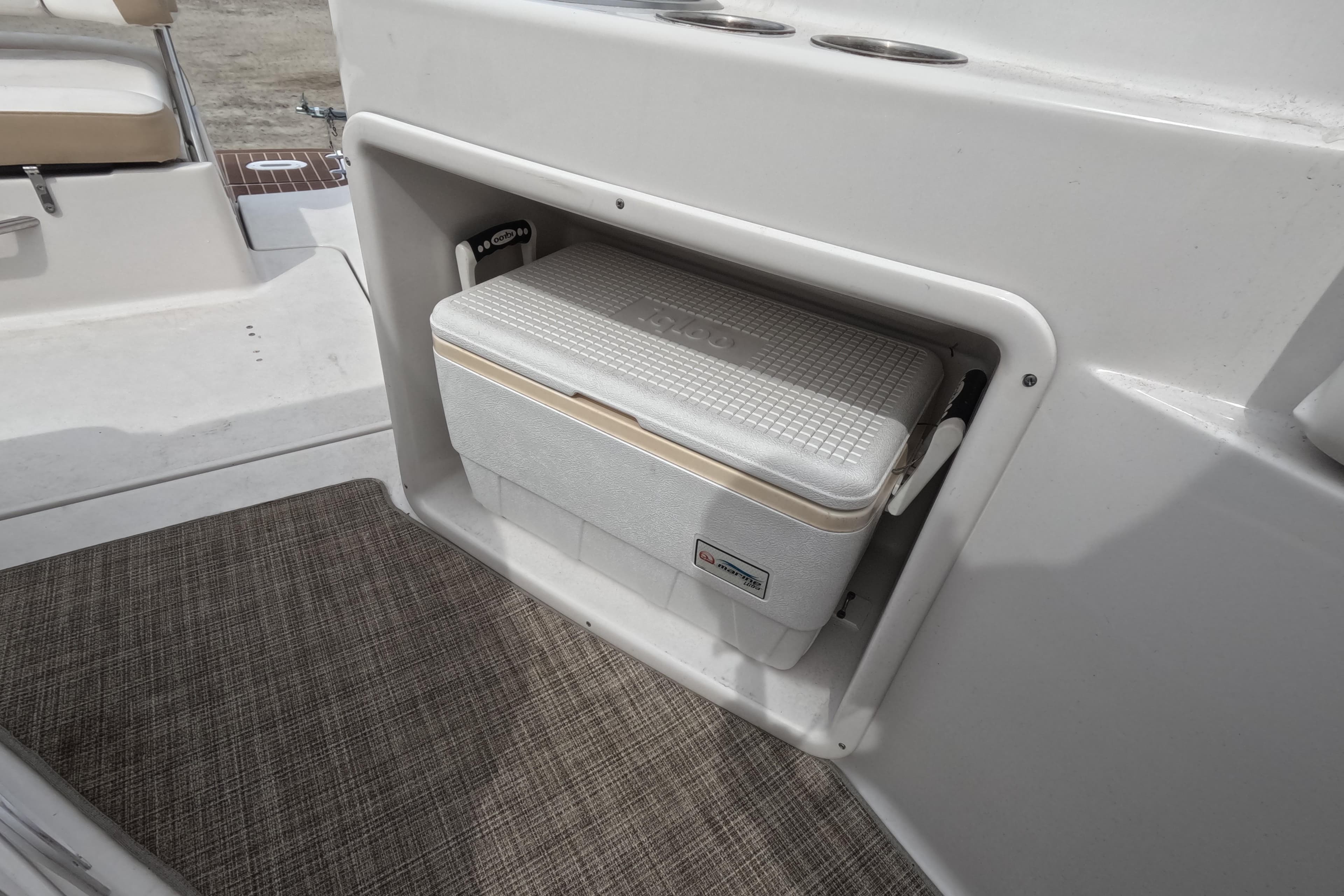 2012 Four Winns V265 boat with built-in cooler storage compartment.