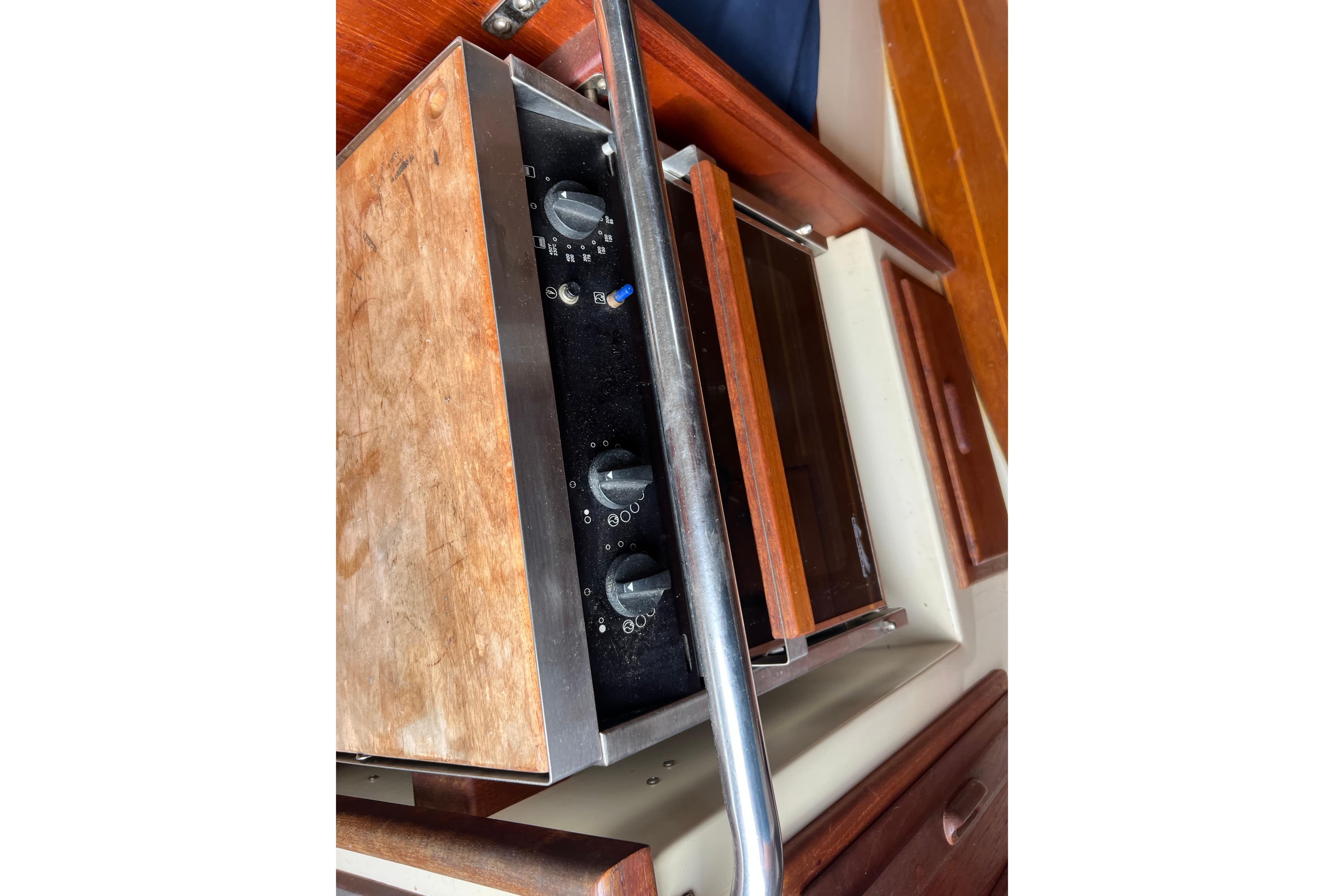 1989 Pacific Seacraft Dana 24 interior stove with wooden cabinetry and control knobs.