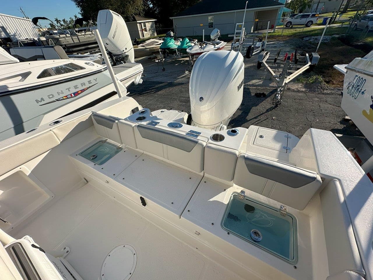 2025 Sailfish 232 boat interior with seating and storage, docked near other boats.