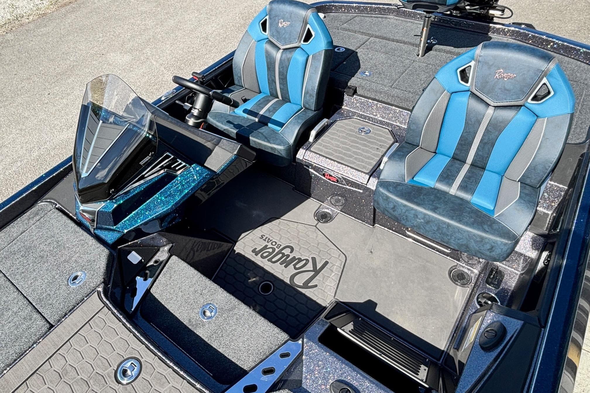 2025 Ranger Z520R boat interior with blue and gray seats, steering console, and storage compartments.