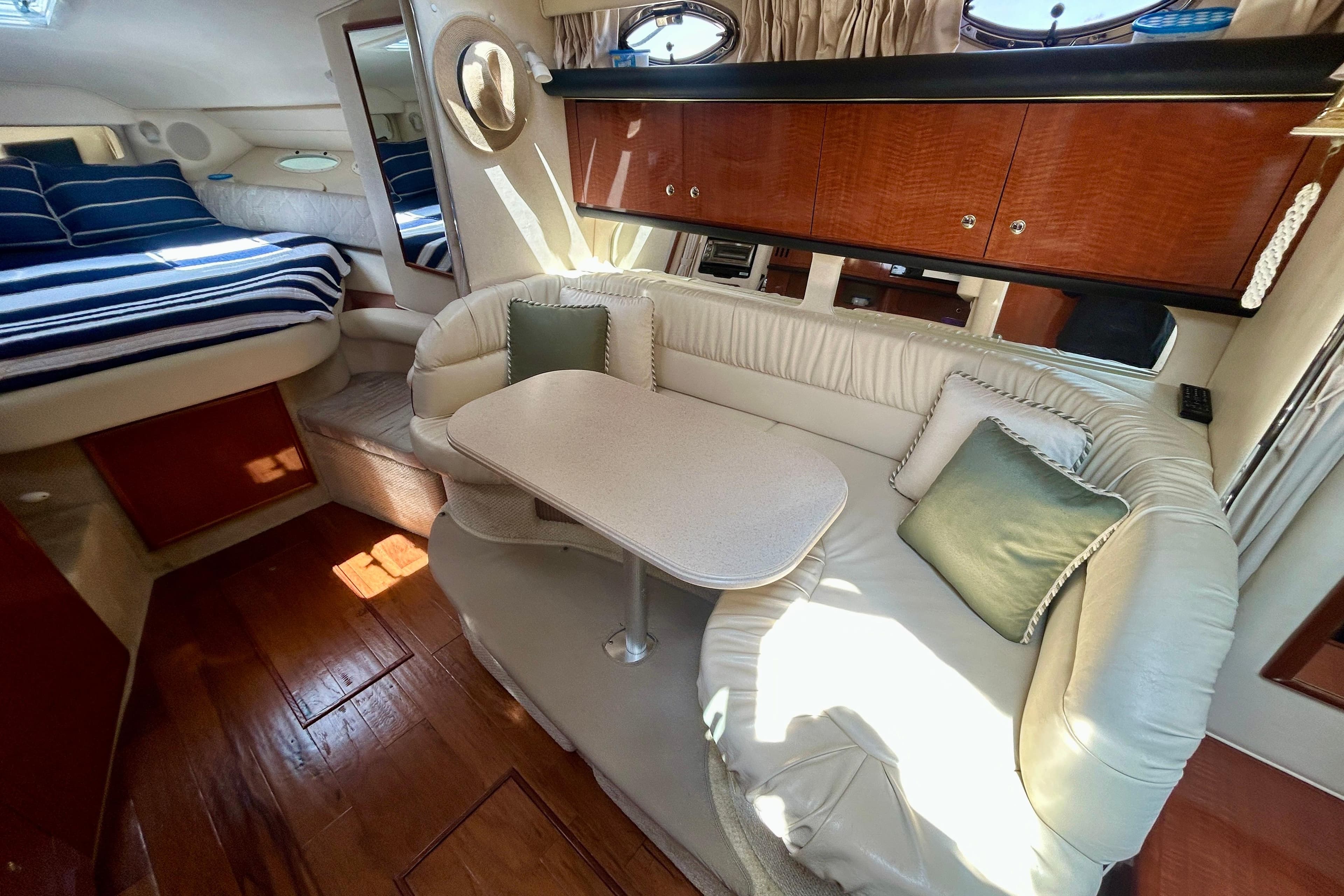 Luxurious interior of 2002 Sea Ray 340 Sundancer yacht with cozy seating and elegant wood finishes.