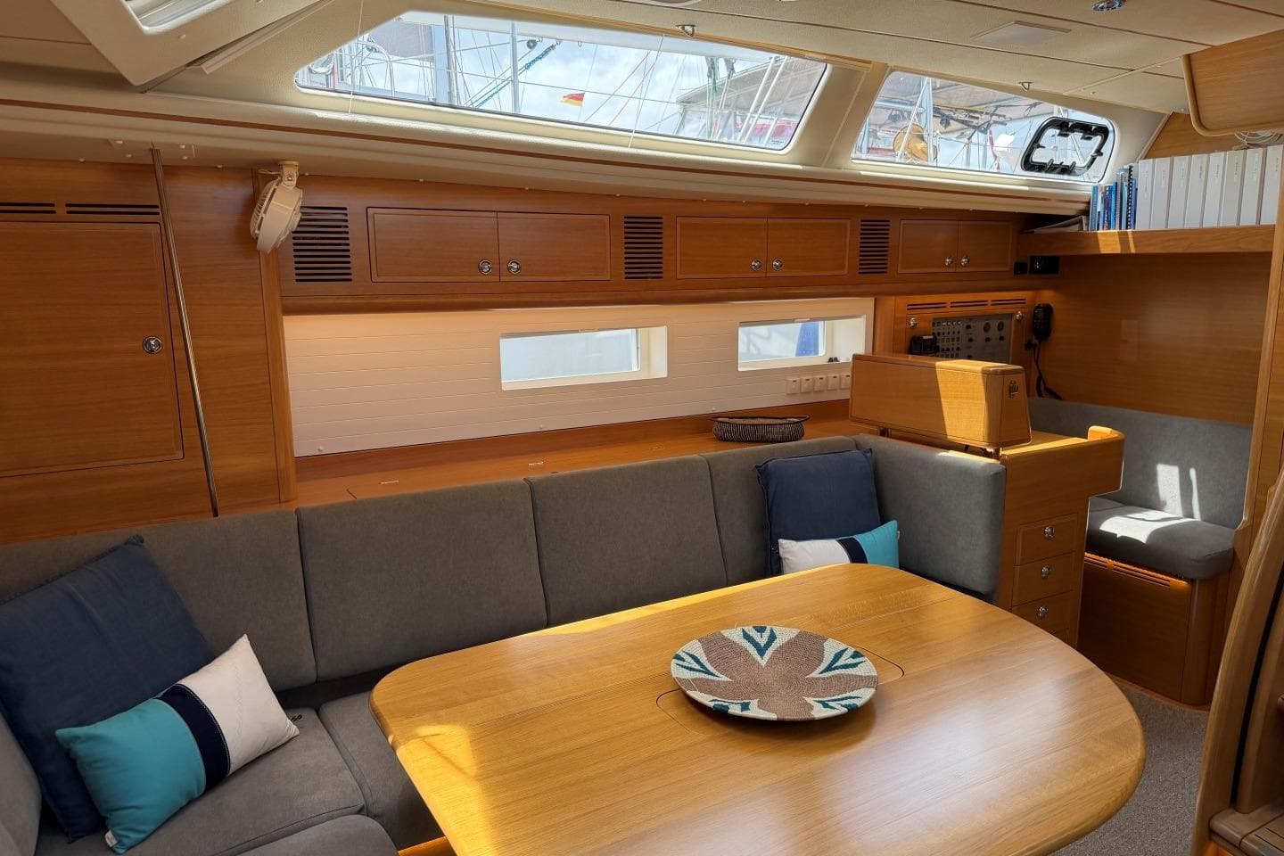 Luxurious interior of 2023 Hallberg-Rassy 57 yacht with elegant wood finish and cozy seating.