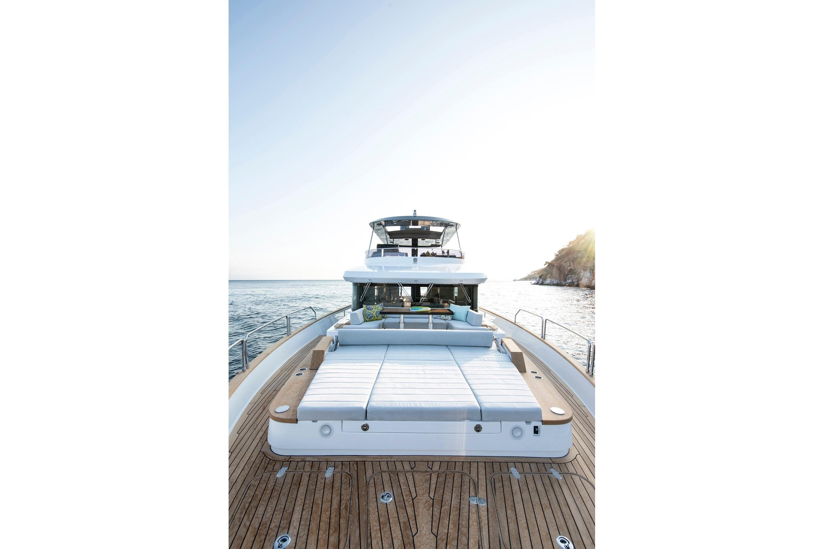 Luxurious 2027 Sirena 68 yacht with spacious deck and sunbed, cruising on serene waters.